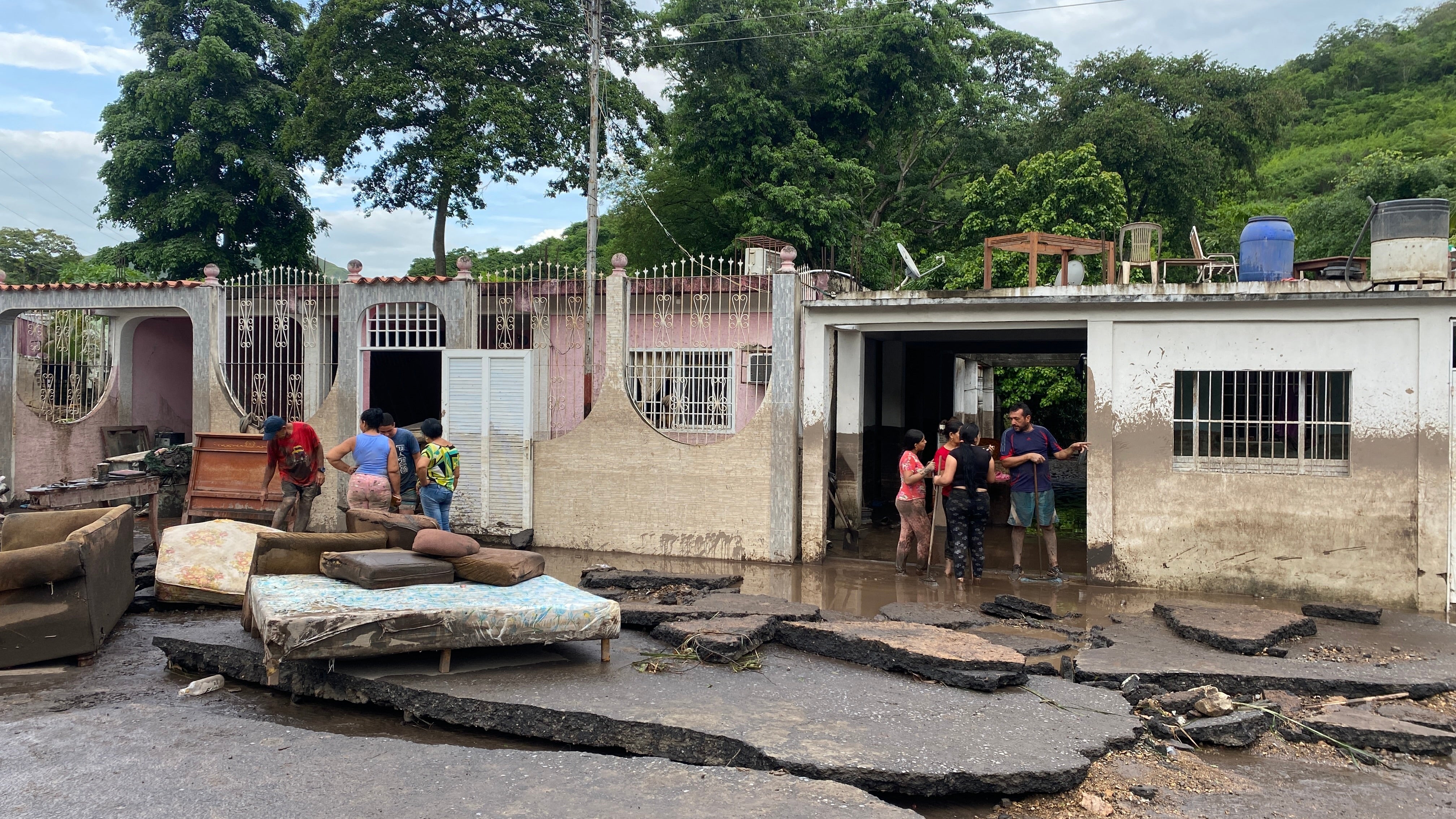 يحاول السكان استعادة ممتلكاتهم من منازلهم التي غمرتها المياه بعد أن فاض نهر بسبب الأمطار الغزيرة عقب مرور إعصار بريل على الطريق من ميكومينا إلى كوماناكوا، ولاية سوكري، فنزويلا