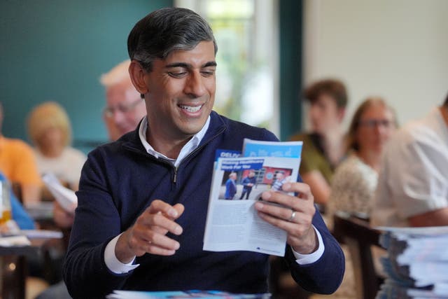 Rishi Sunak sorts Conservative election leaflets on the final day of the campaign (Jonathan Brady/PA)