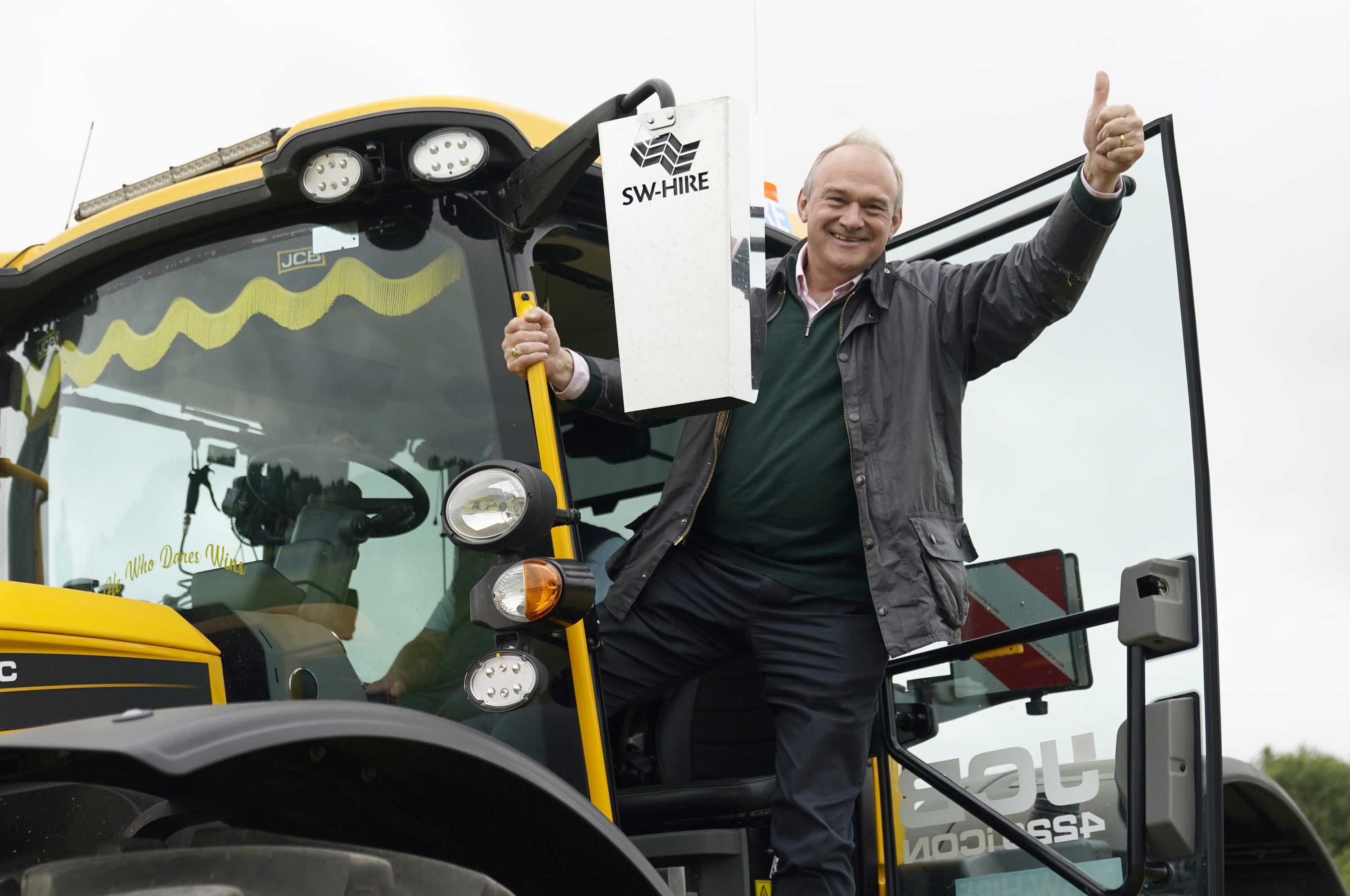 Sir Ed Davey climbs from a yellow tractor on the final day of the campaign (Andrew Matthews/PA)