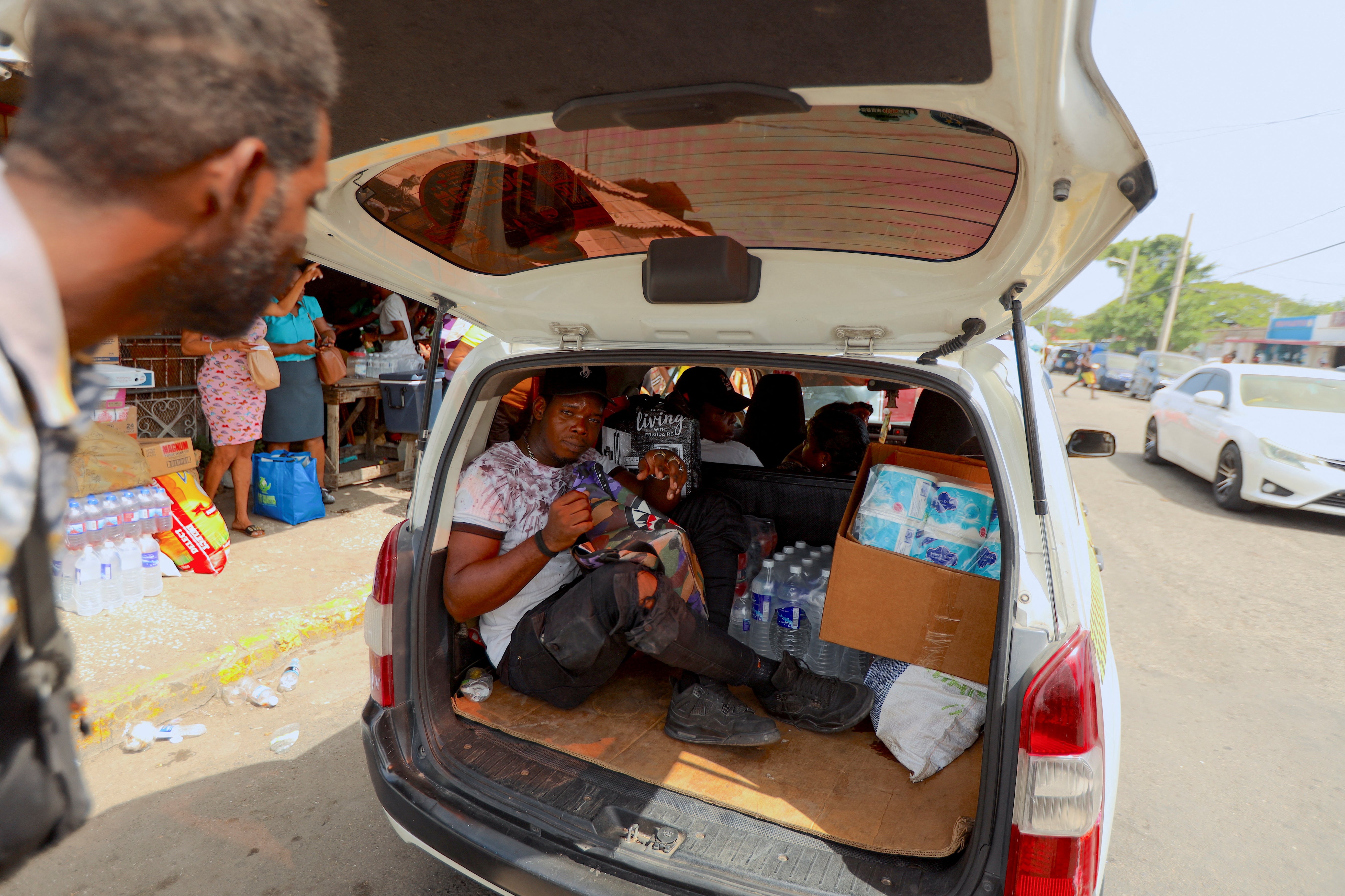 A man sits in the back of a car loaded with supplies in Kingston, Jamaica on Tuesday ahead of Hurricane Beryl