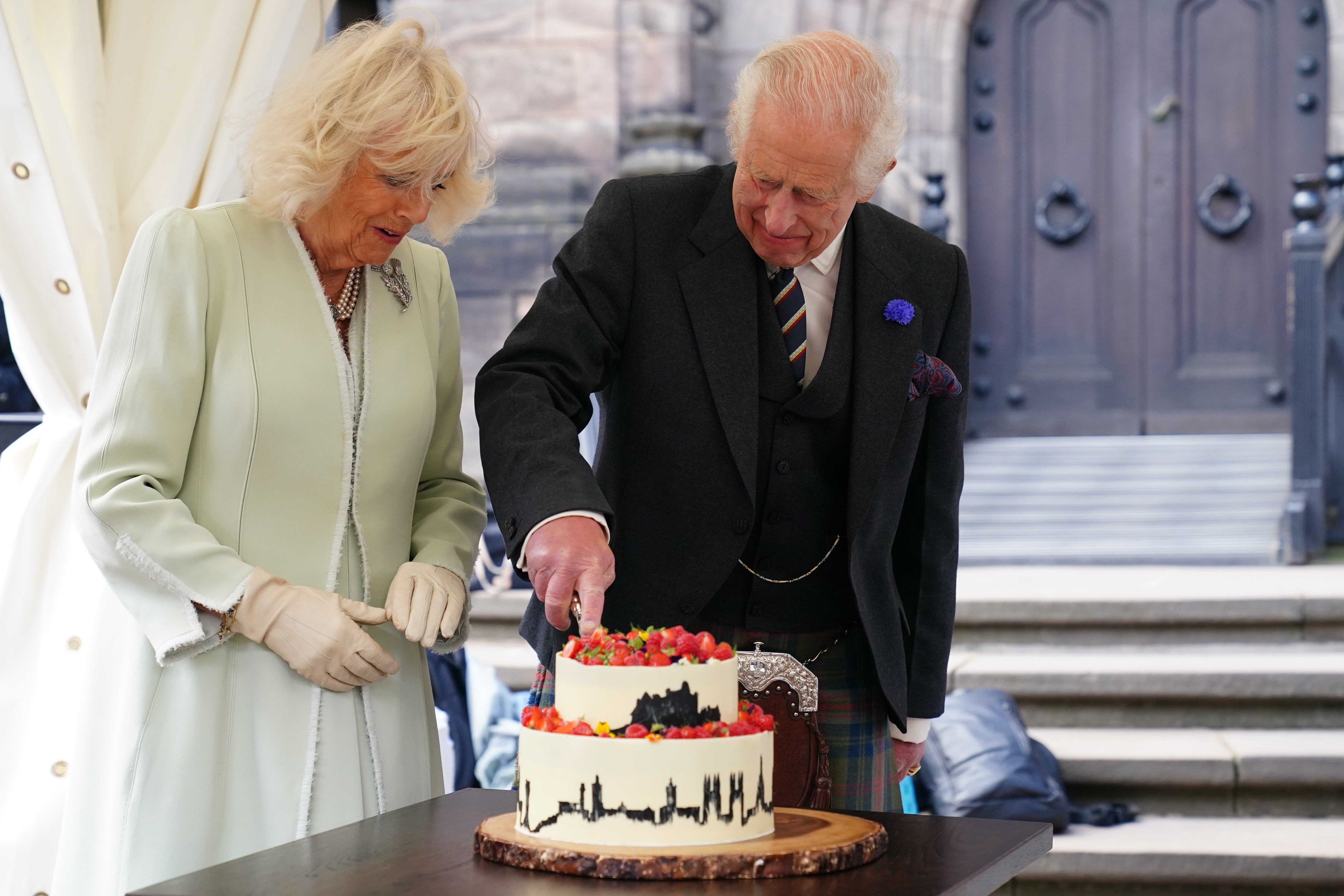 The King and Queen cut a cake made by 2020 Great British Bake Off winner Peter Sawkins (Jane Barlow/PA)