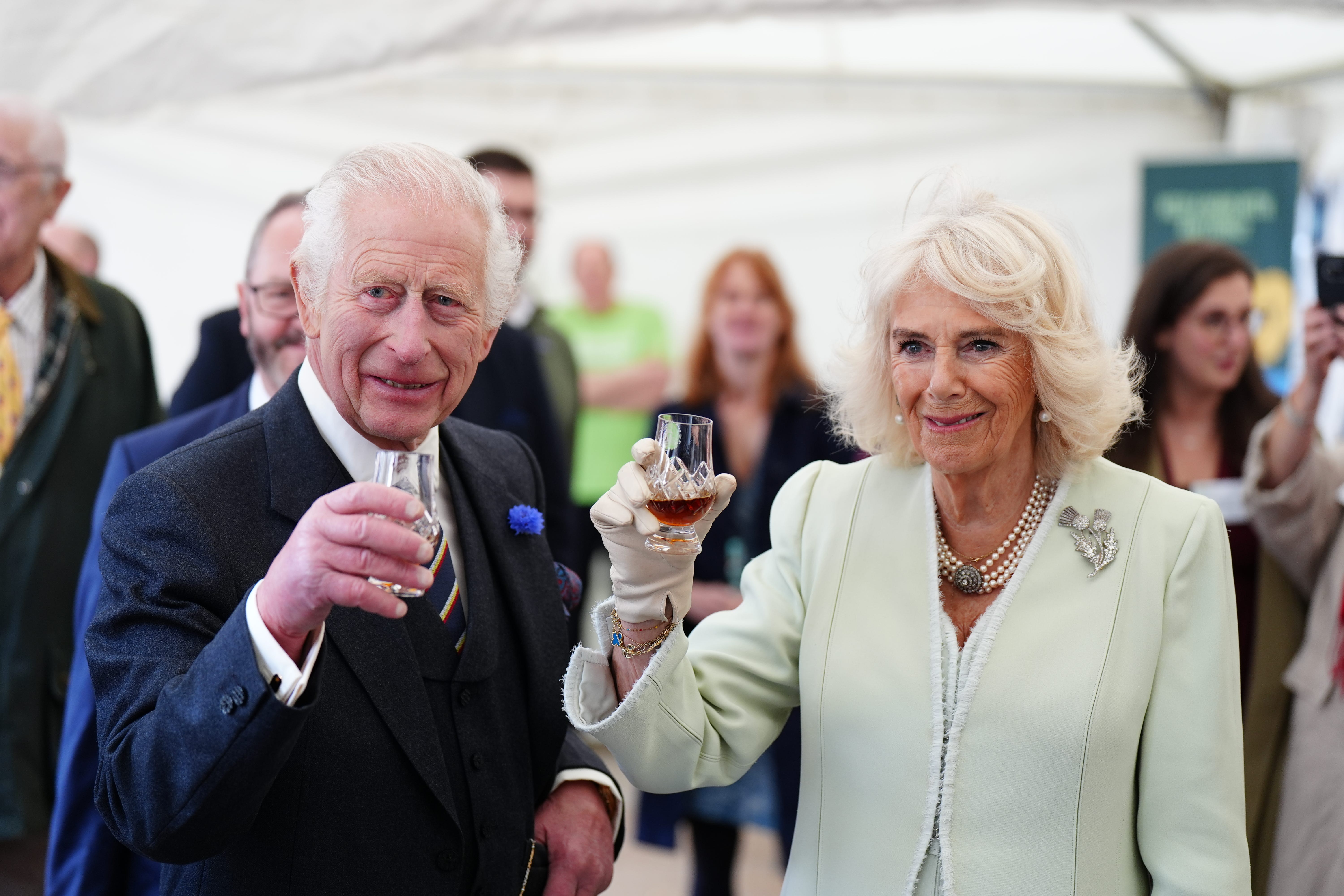 The King and Queen try a glass of whisky as they attend a celebration at Edinburgh Castle to mark the 900th anniversary of the City of Edinburgh (Jane Barlow/PA)