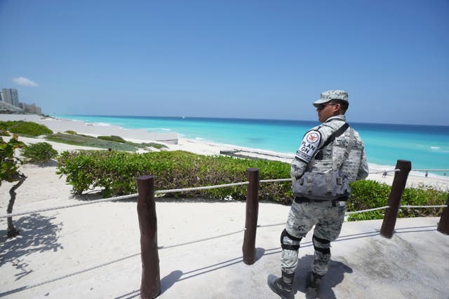<p>A Mexican soldier stands guard on a beach  in Cancun, Mexico</p>