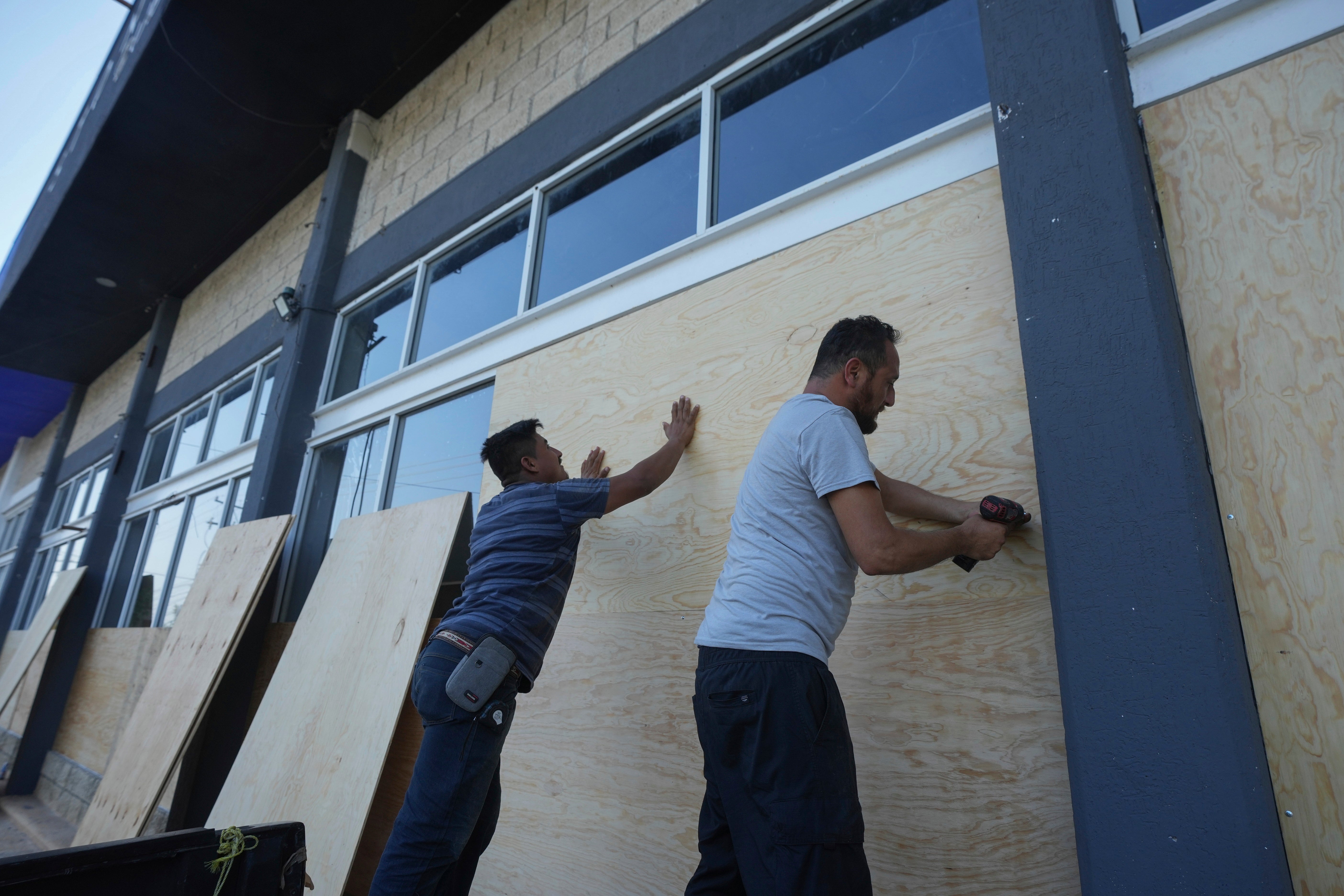 Furniture store employees board up windows for protection ahead of Hurricane Beryl’s expected arrival
