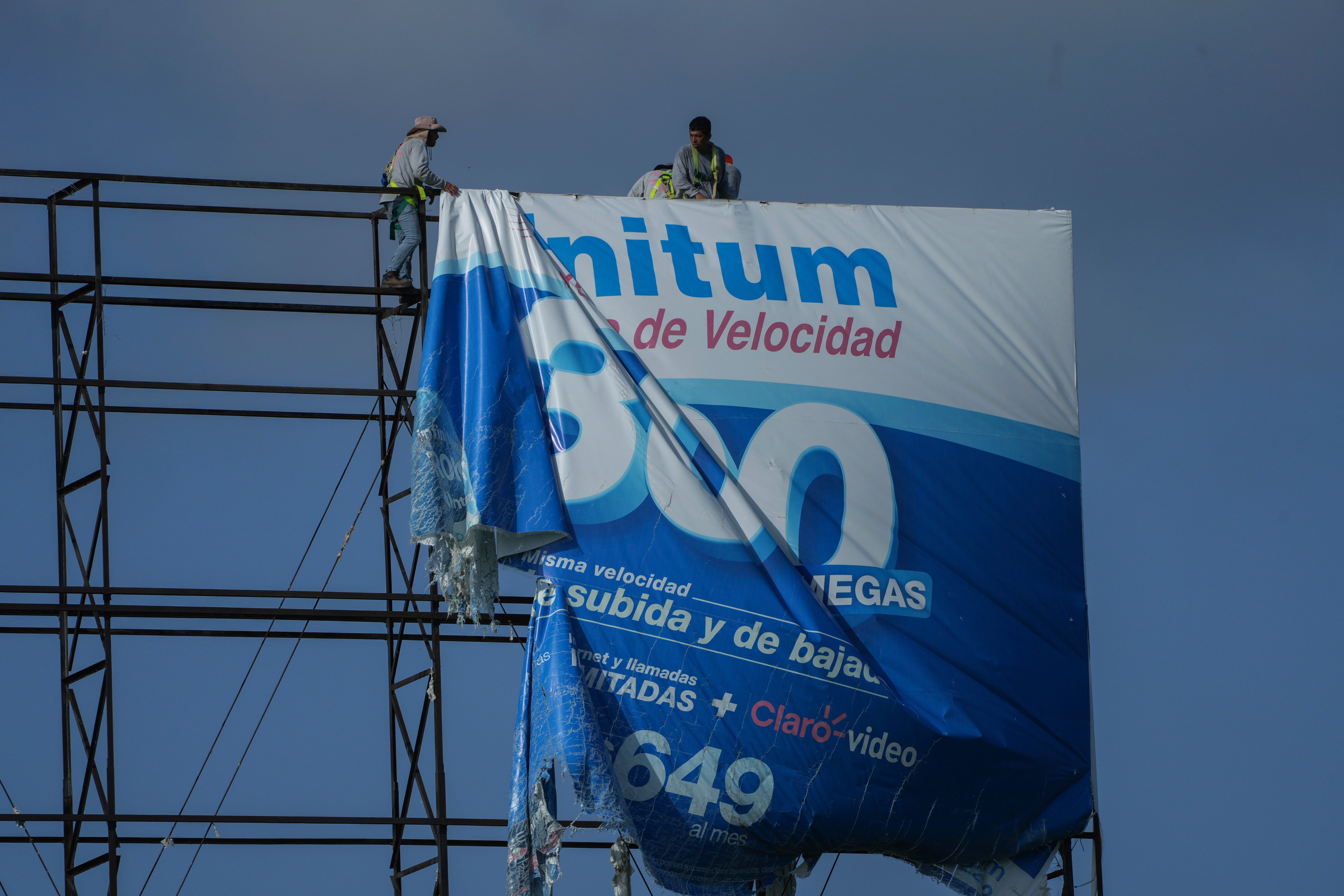 Workers remove a billboard advertisement ahead of Hurricane Beryl in Playa del Carmen, Mexico on July 3
