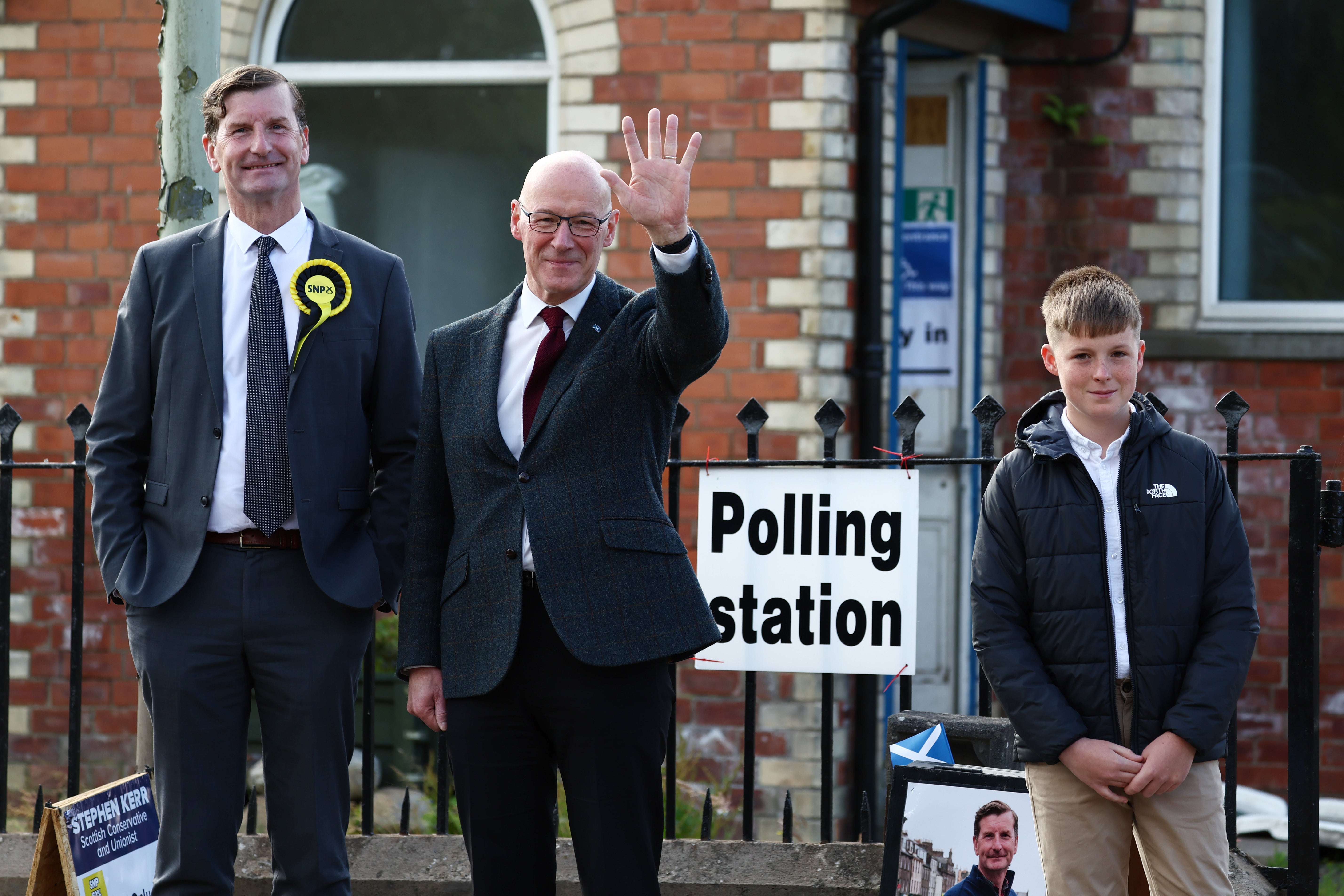 First Minister of Scotland, John Swinney, arrives to vote with SNP Candidate Dave Doogan and son Matthew