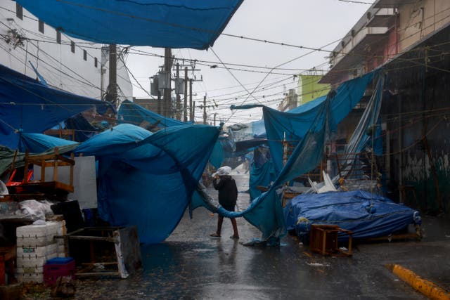 <p>A person walks down a street in Kingston, Jamaica as Hurricane Beryl brings life-threatening rain and wind to the island </p>