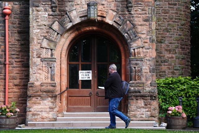 A man arrives to cast his vote in the General Election at Pollokshields Burgh Halls in Glasgow (Andrew Milligan/PA)