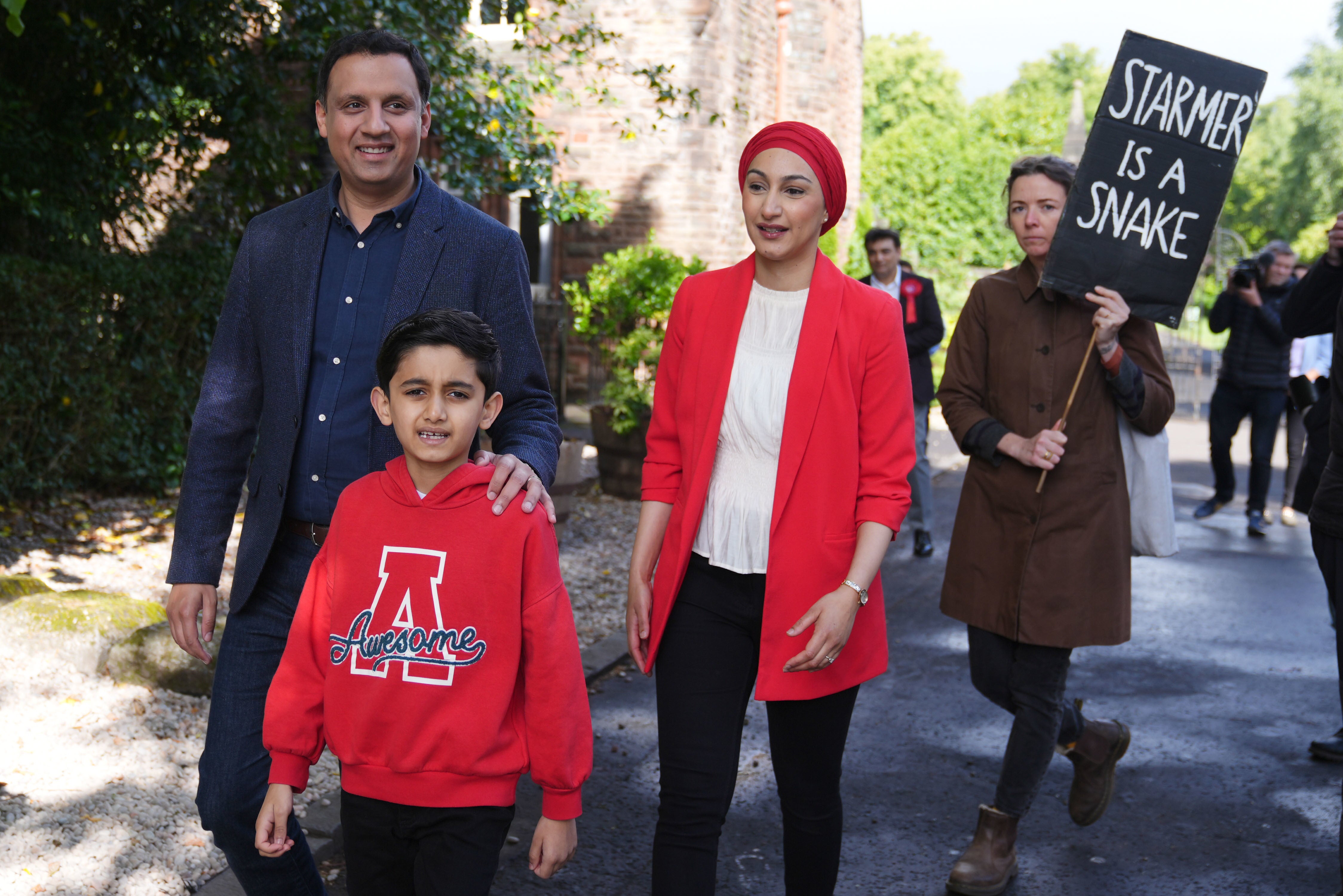 Scottish Labour leader Anas Sarwar, his wife Furheen and their son Aliyan were followed by a protester as they attended Pollokshields Burgh Halls in Glasgow to vote (Andrew Milligan/PA)