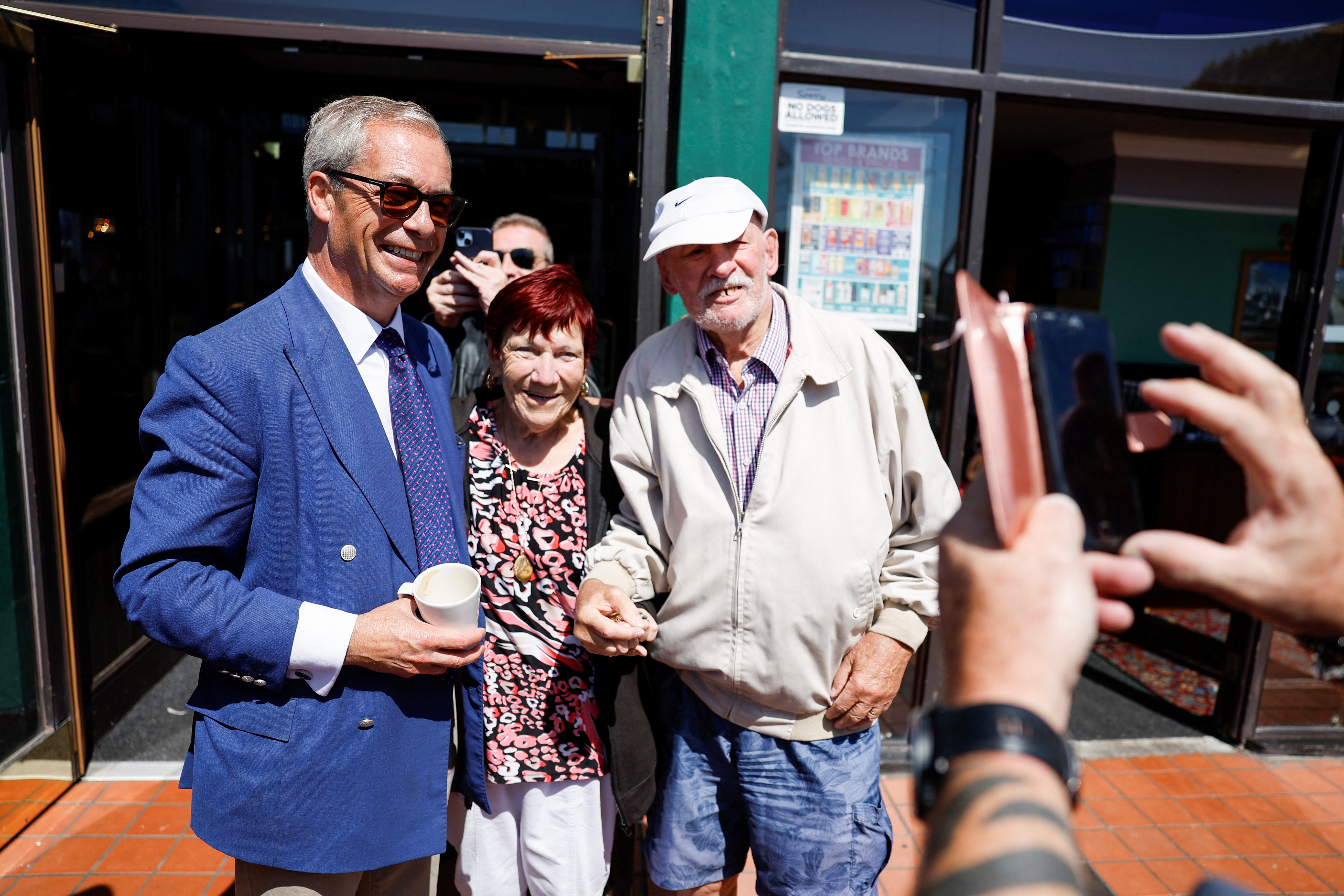 Nigel Farage poses with people, on the day of the general election, in Clacton-on-Sea, Britain