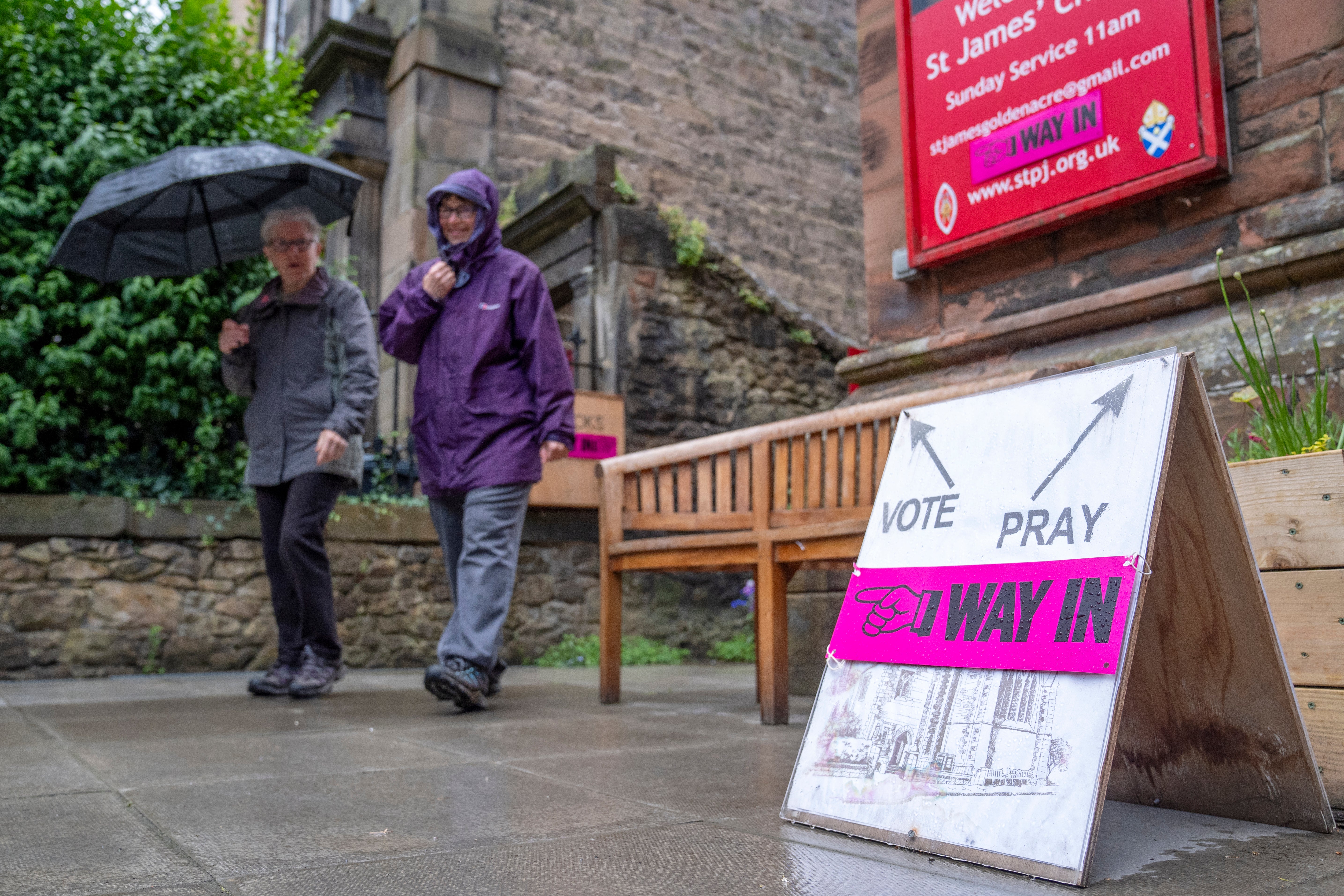 Members of the public leave after casting their vote in the 2024 General Election at St James' Church, Goldenacre, in Edinburgh