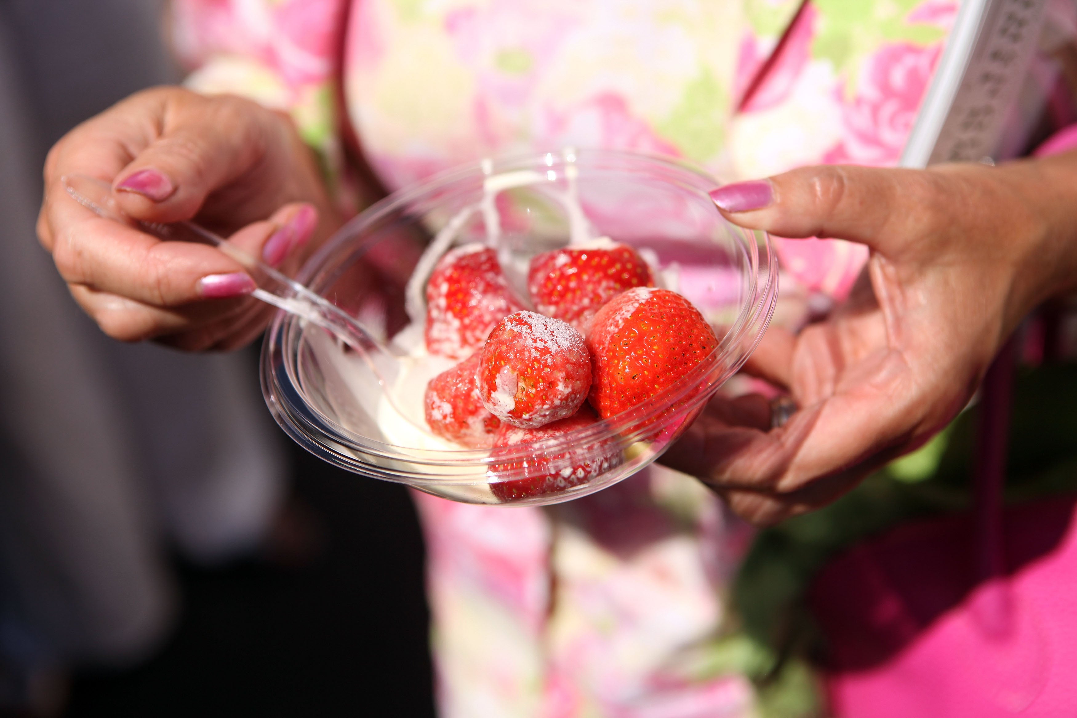 A spectator enjoys the traditional strawberries and cream at Wimbledon