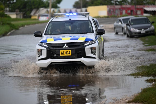 <p>A police car drives through a flooded street in Kingston, Jamaica on Thursday following Hurricane Beryl</p>