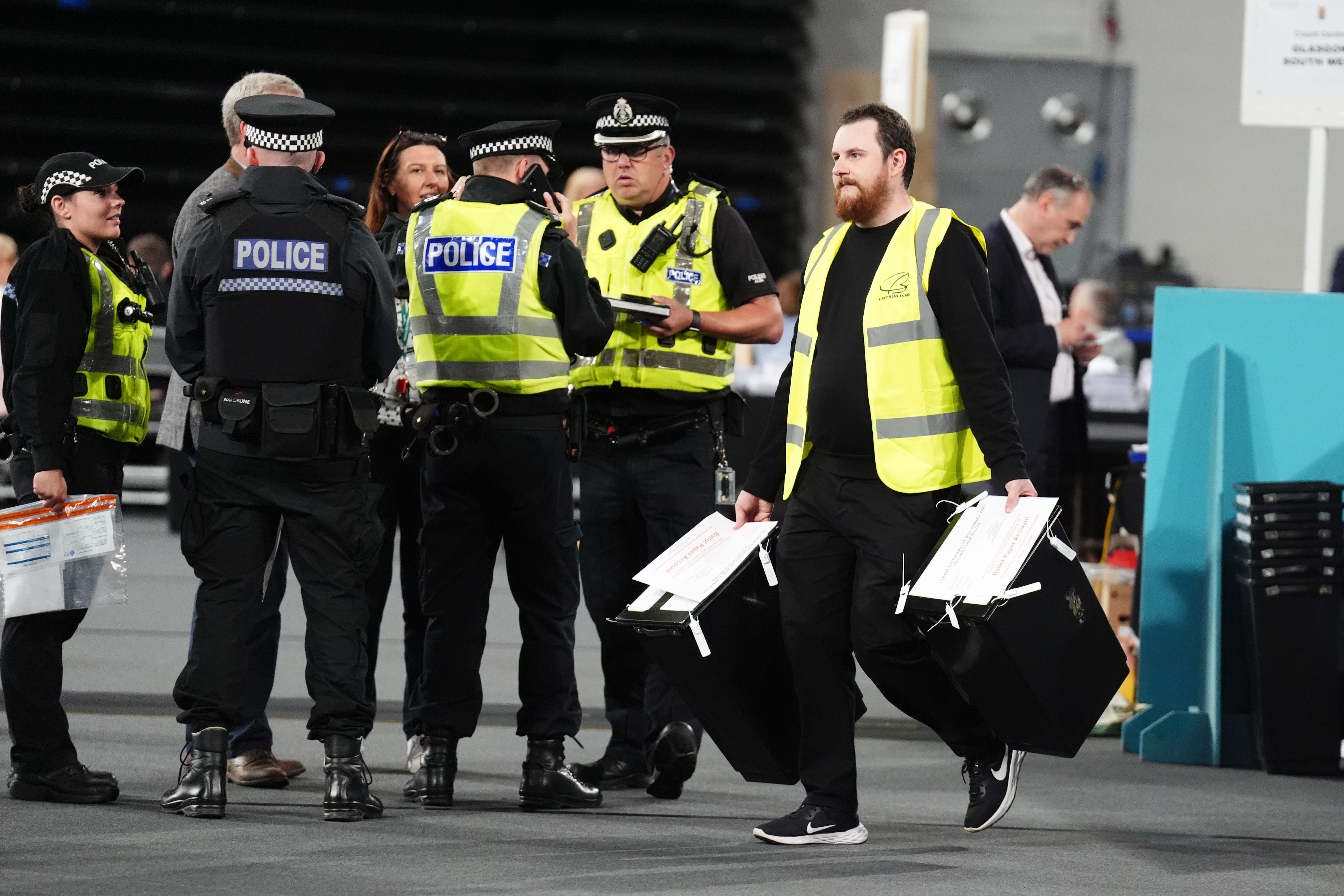 Police accompanying ballot boxes as they are carried in to the Emirates Arena in Glasgow (Andrew Milligan/PA)