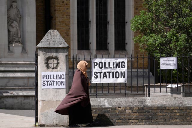 <p>A woman leaves after casting her vote at a polling station in London</p>