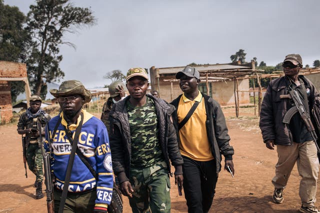<p>Commanders of the militia group Codeco walk through Linga village in Ituri province of Congo</p>