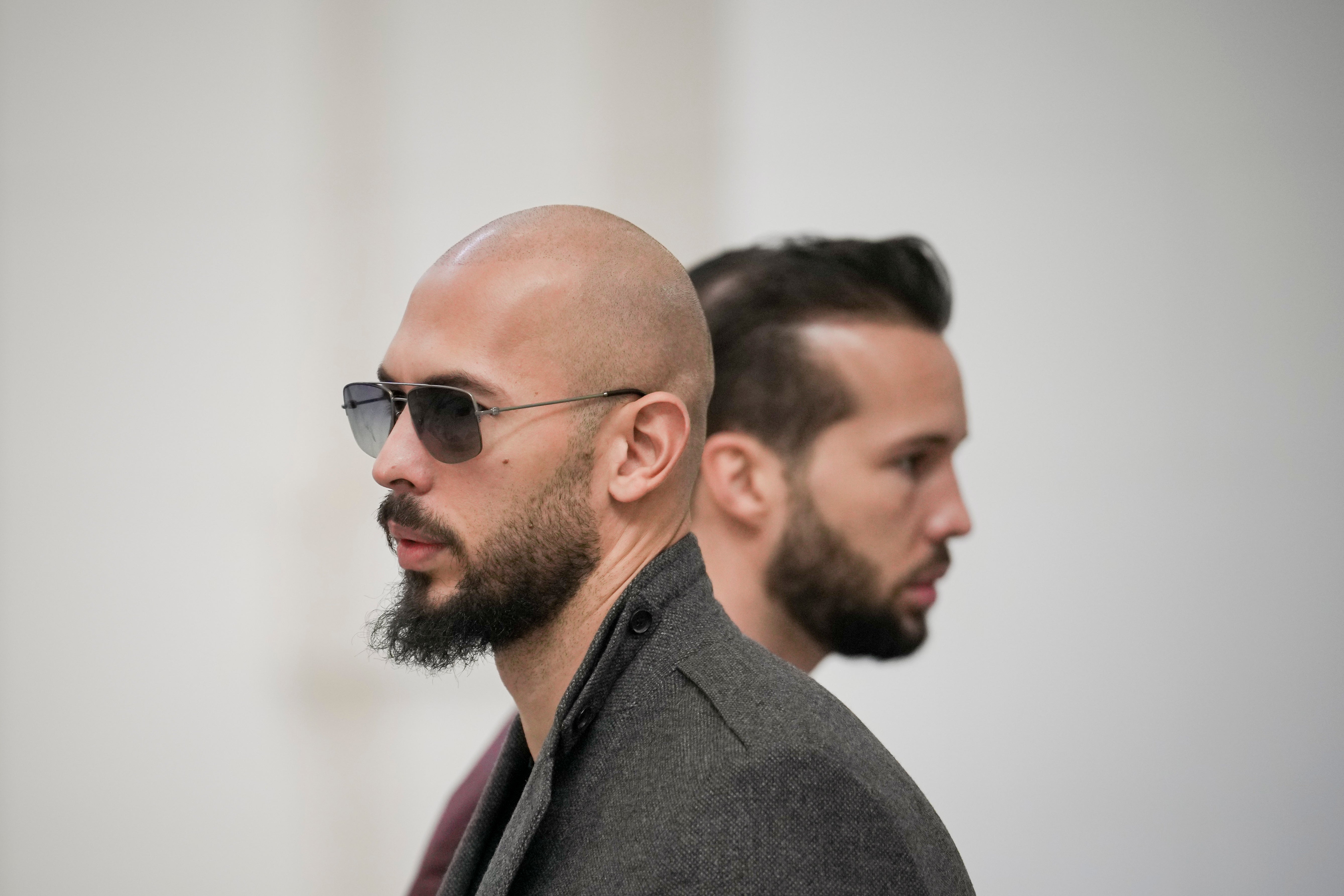 Andrew Tate, left, and his brother Tristan, right, wait inside the Court of Appeals building in Bucharest, Romania, Tuesday, 30 Jan 2024