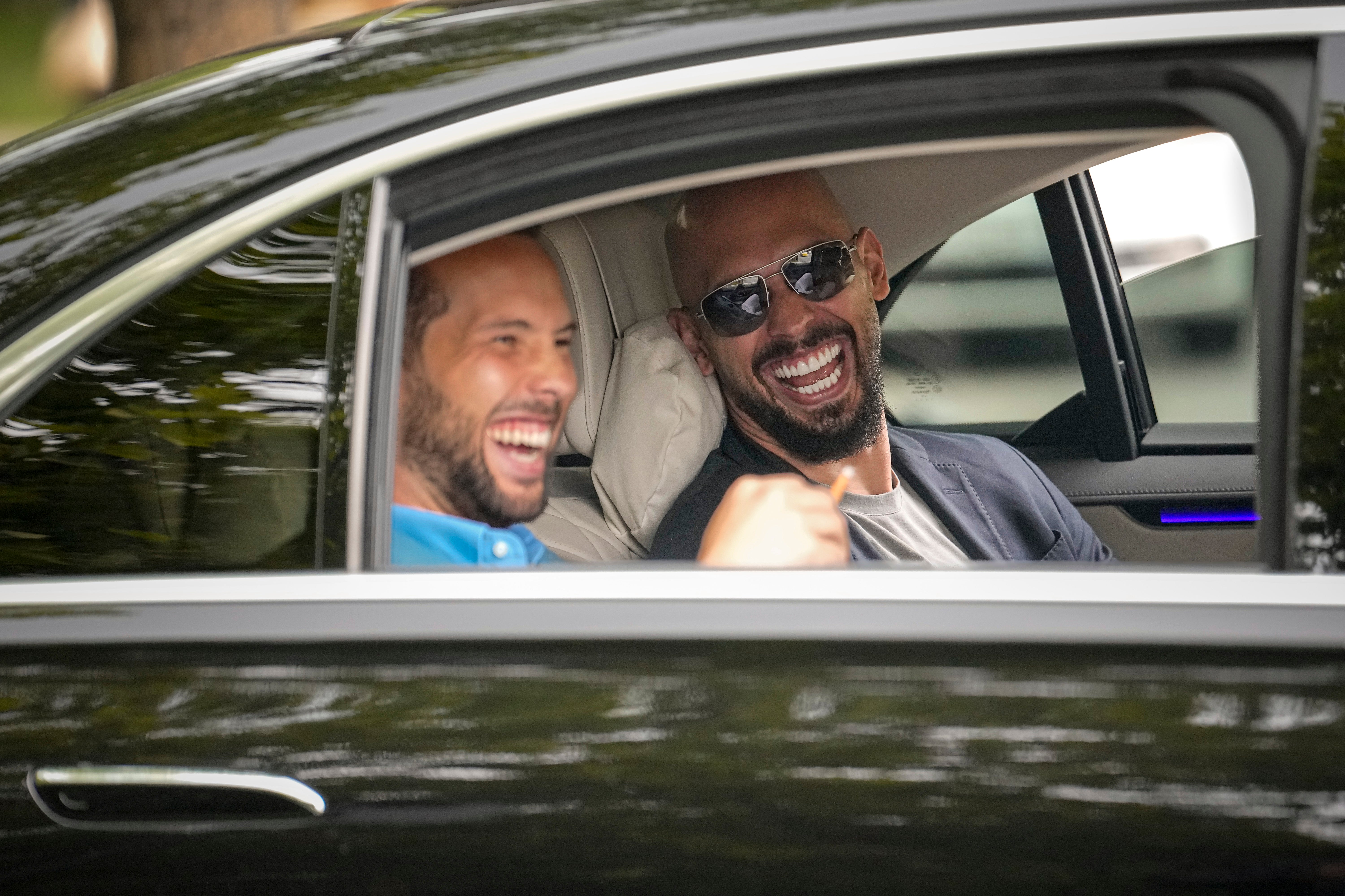 Andrew Tate, right, and his brother Tristan laugh as they leave the Bucharest Tribunal in Bucharest, Romania, Wednesday, 8 May 2024