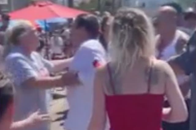 <p>A woman at a Los Angeles Fourth of July parade tries to hold actor Danny Trejo back after he tried to punch a man who threw a water balloon at him </p>
