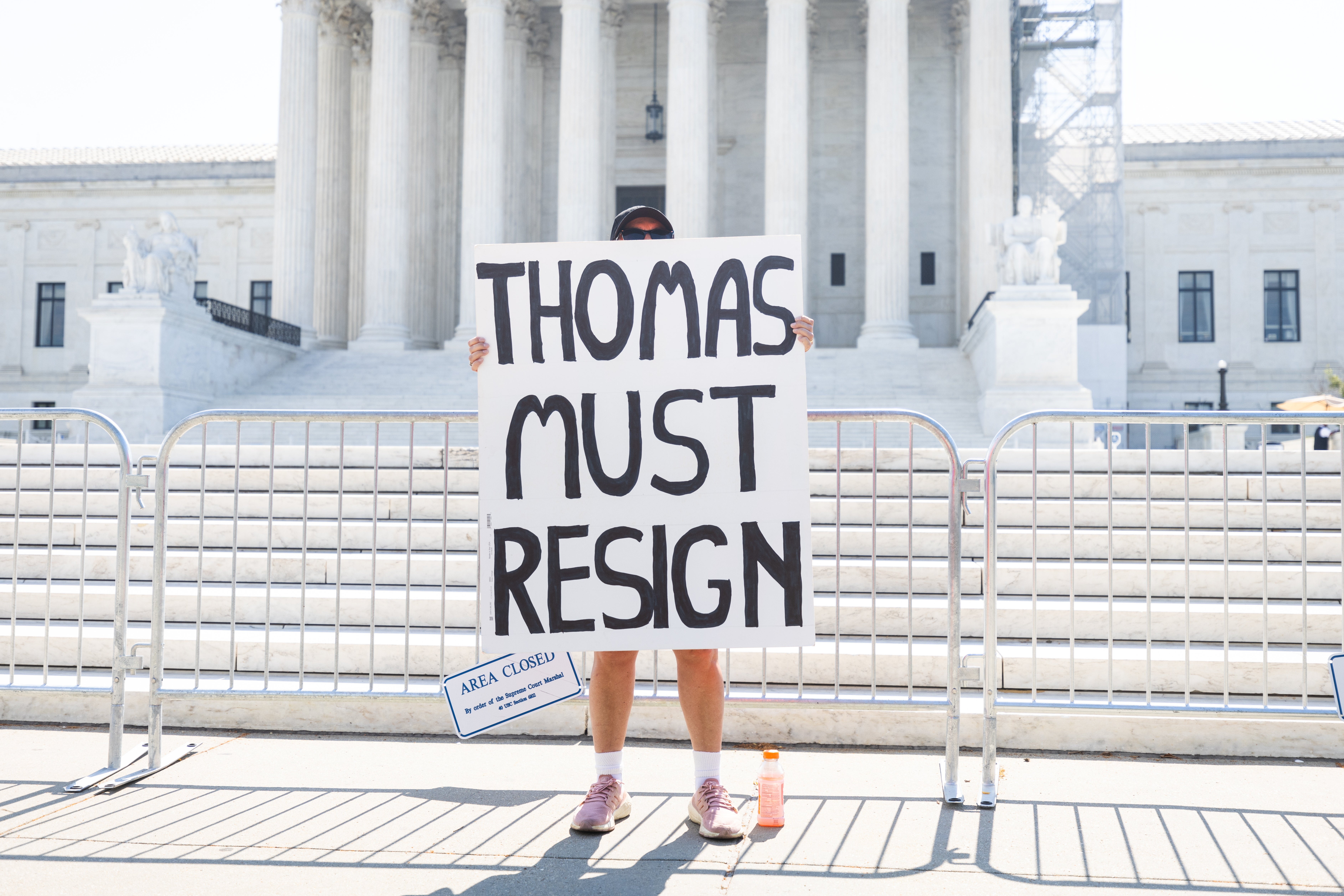 A lone protester holds a sign calling on Supreme Court Justice Clarence Thomas to resign to resign as the high judges issued opinions on three cases, including a federal ban on bump stocks, in Washington, on 14 June 2024