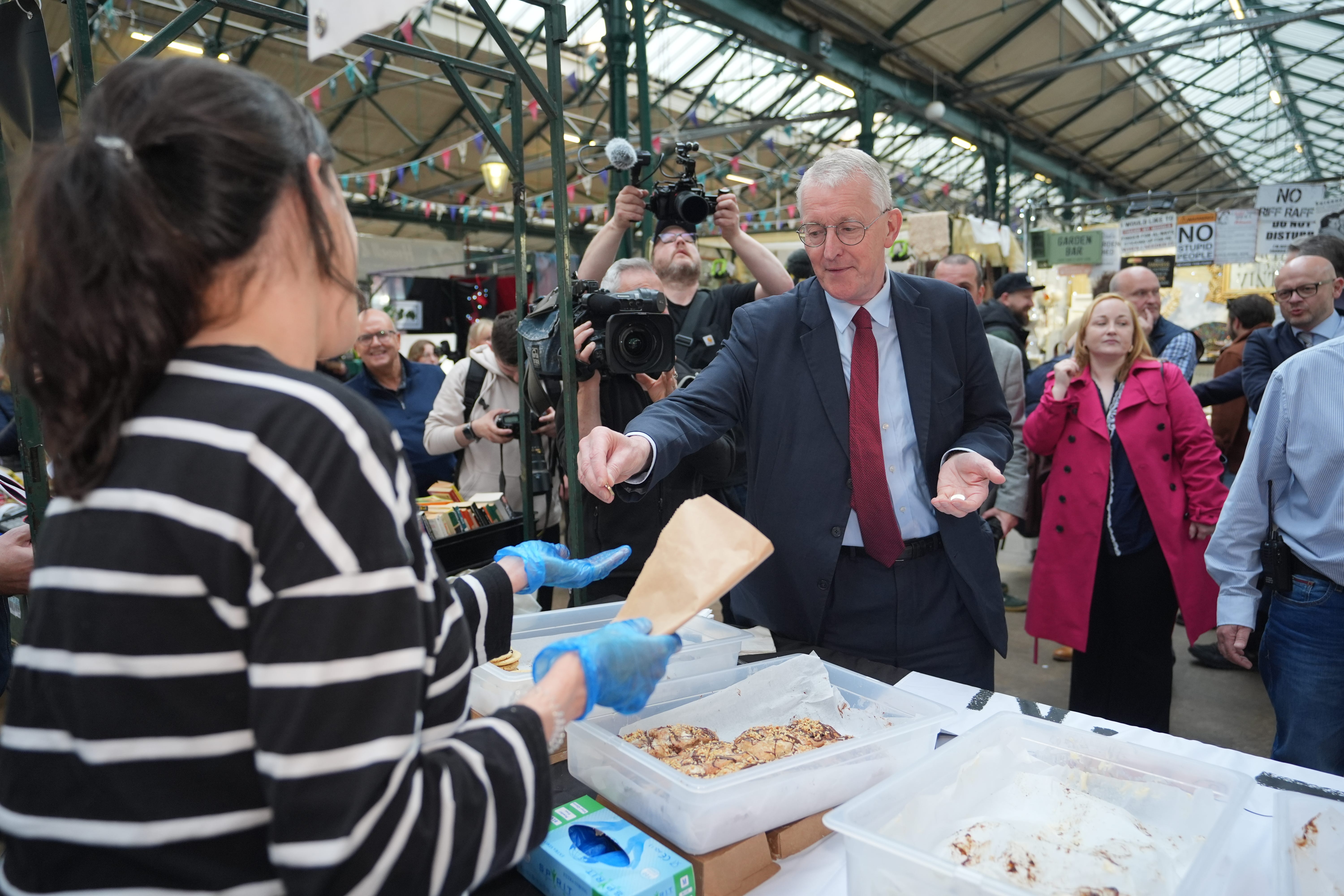 Northern Ireland Secretary Hilary Benn buys cookies during a visit to St George’s Market in Belfast, following the Labour Party’s victory in the 2024 General Election (Niall Carson/PA)