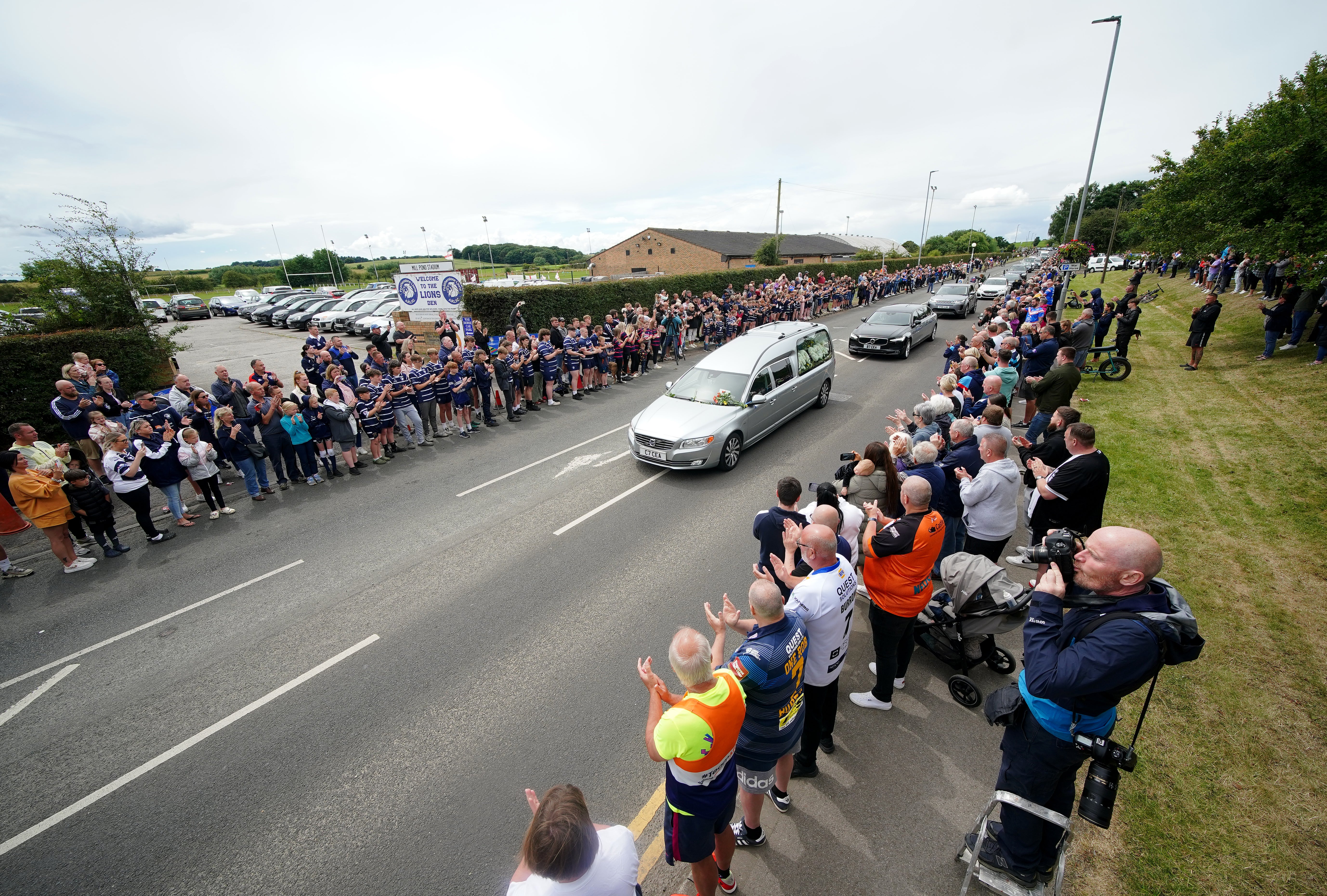 Hundreds of mourners have lined the streets as the funeral cortege makes its way to the service