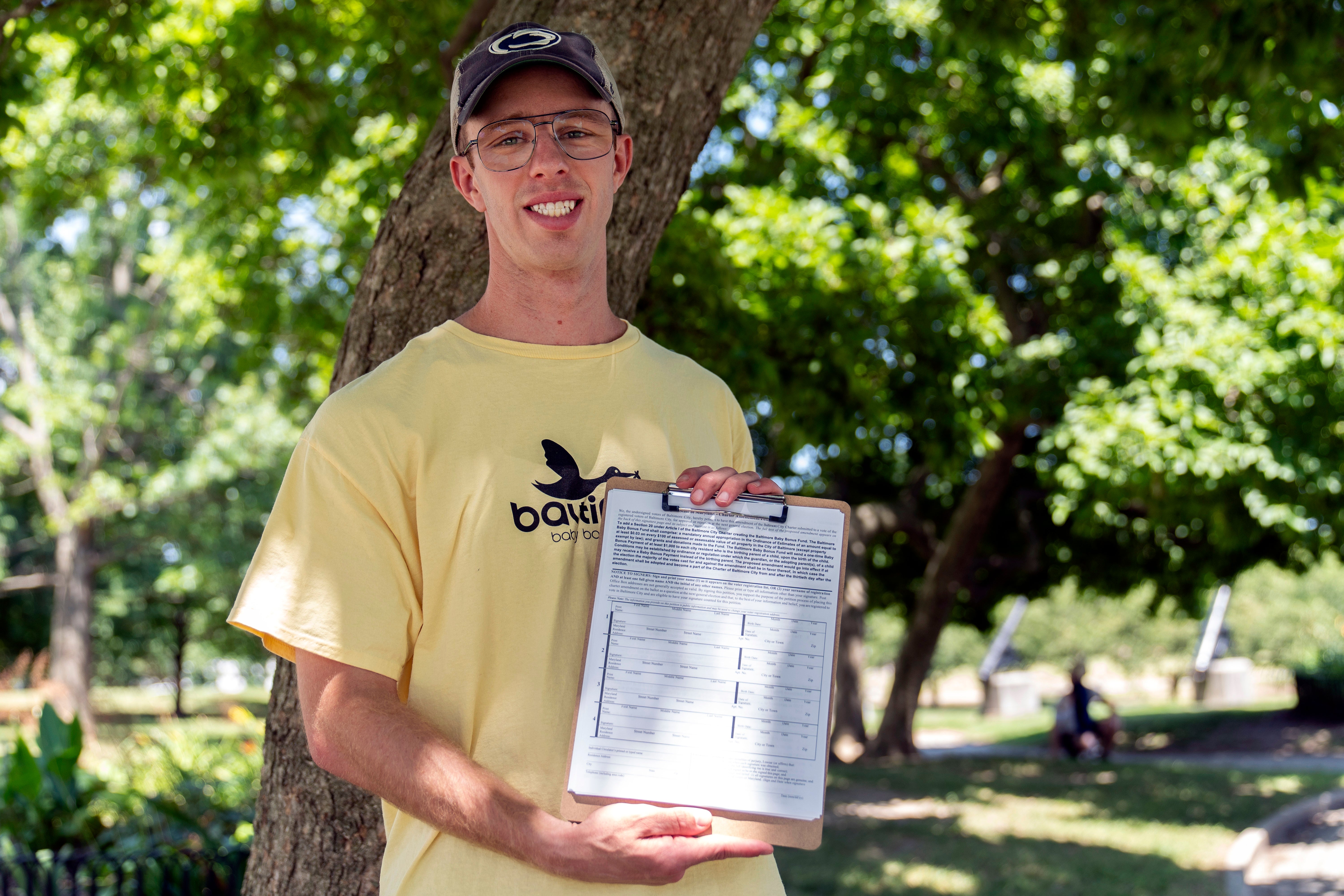 Nate Golden, president of the Maryland Child Alliance, poses for a portrait with a petition form for the Baltimore Baby Fund