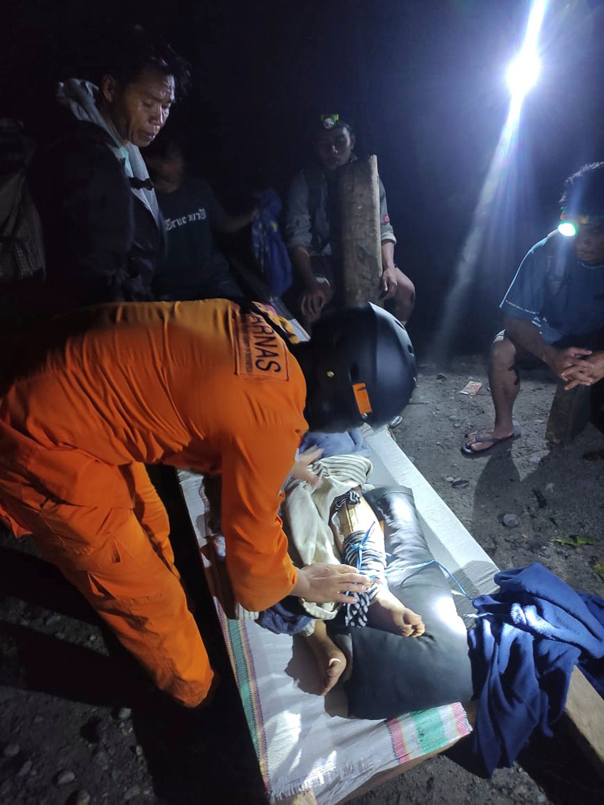 Rescuers search for dozens buried in an Indonesian landslide that killed at least 11 people