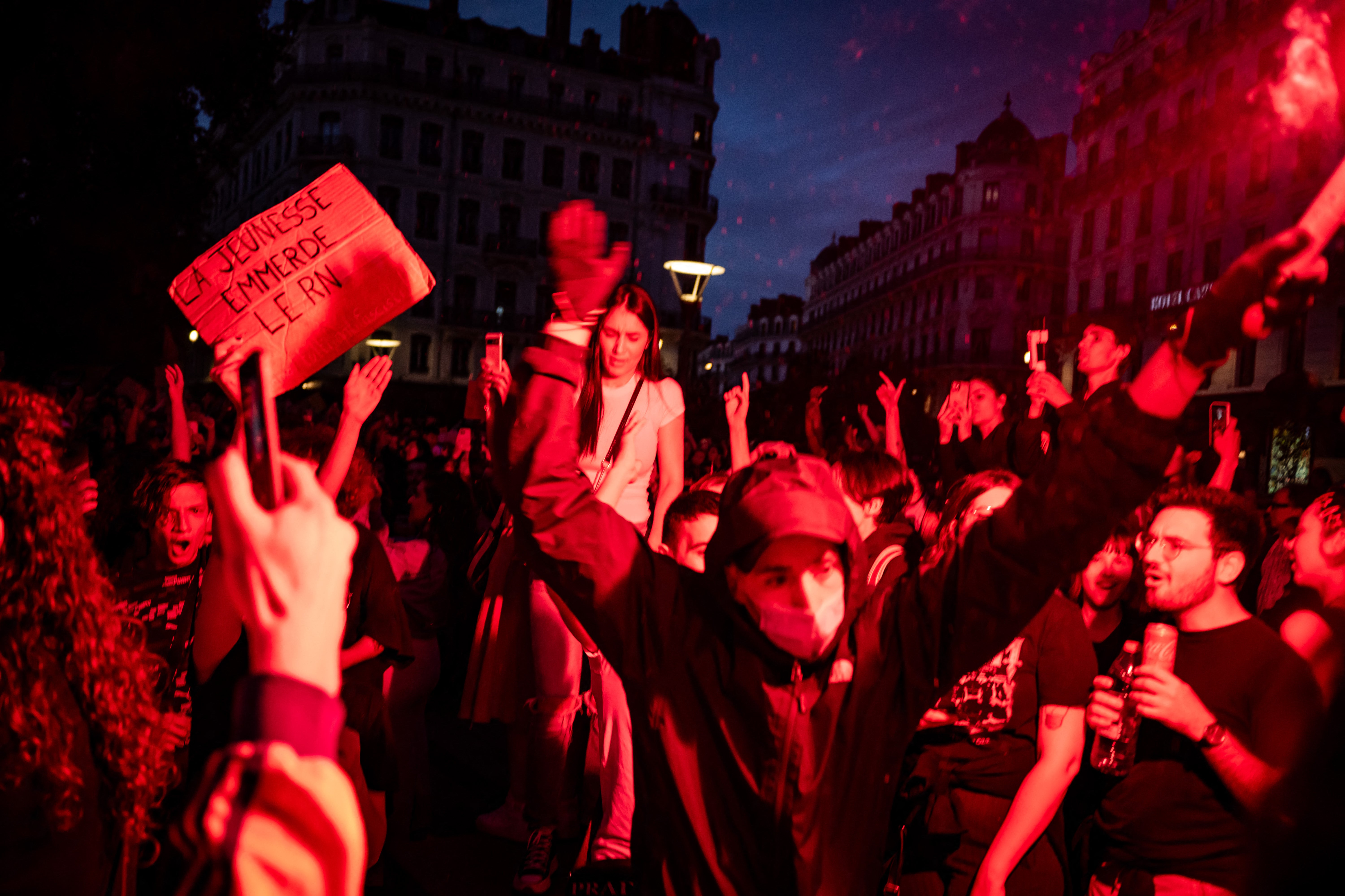 Left wing supporters light red flares as they celebrate during a rally after the announcement of the results of the second round of France's parliamentary elections in Lyon, eastern France