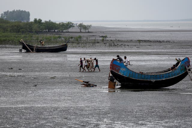<p>Fishermen carry a fishing net at the bank of Naf river, in Teknaf area of Cox's Bazar</p>