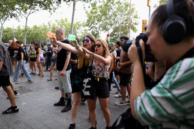 <p>Tourists are sprayed with water guns in Barcelona in July 2024 as locals protested overtourism</p>