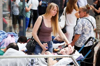 A woman touches a child patient near Ohmatdyt Children’s Hospital after it was damaged in a Russian attack