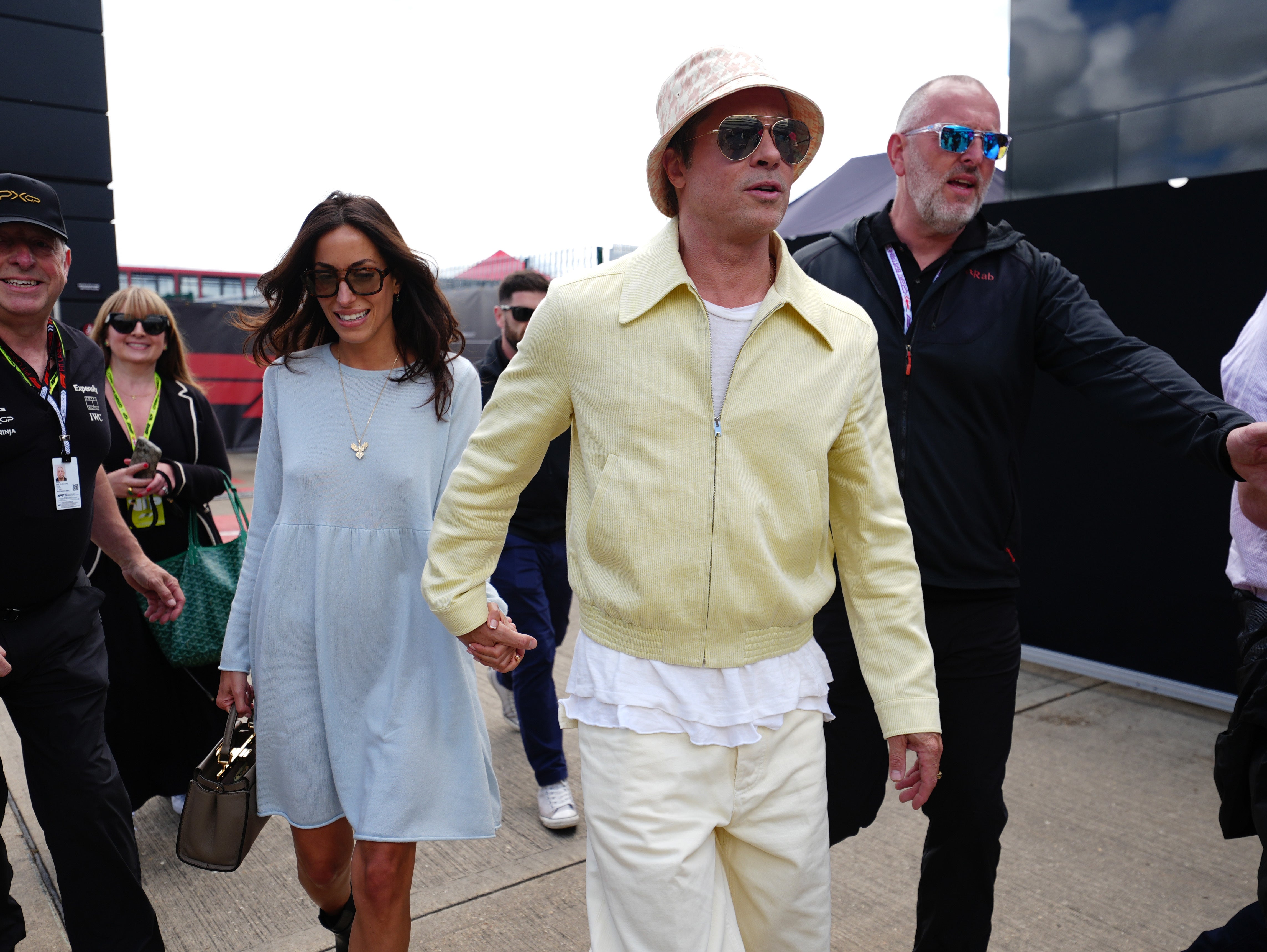 Brad Pitt and Ines de Ramon arrive in complimenting primary colours at Silverstone (David Davies/PA)