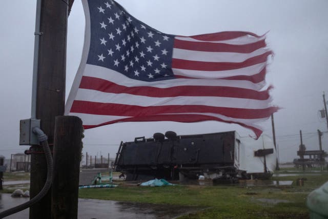 <p>An American flag waves near a trailer home left overturned by Hurricane Beryl winds in Surfside Beach, Texas on July 8. A 53-year-old man died in the storm when a tree hit his home in Humble, Texas </p>