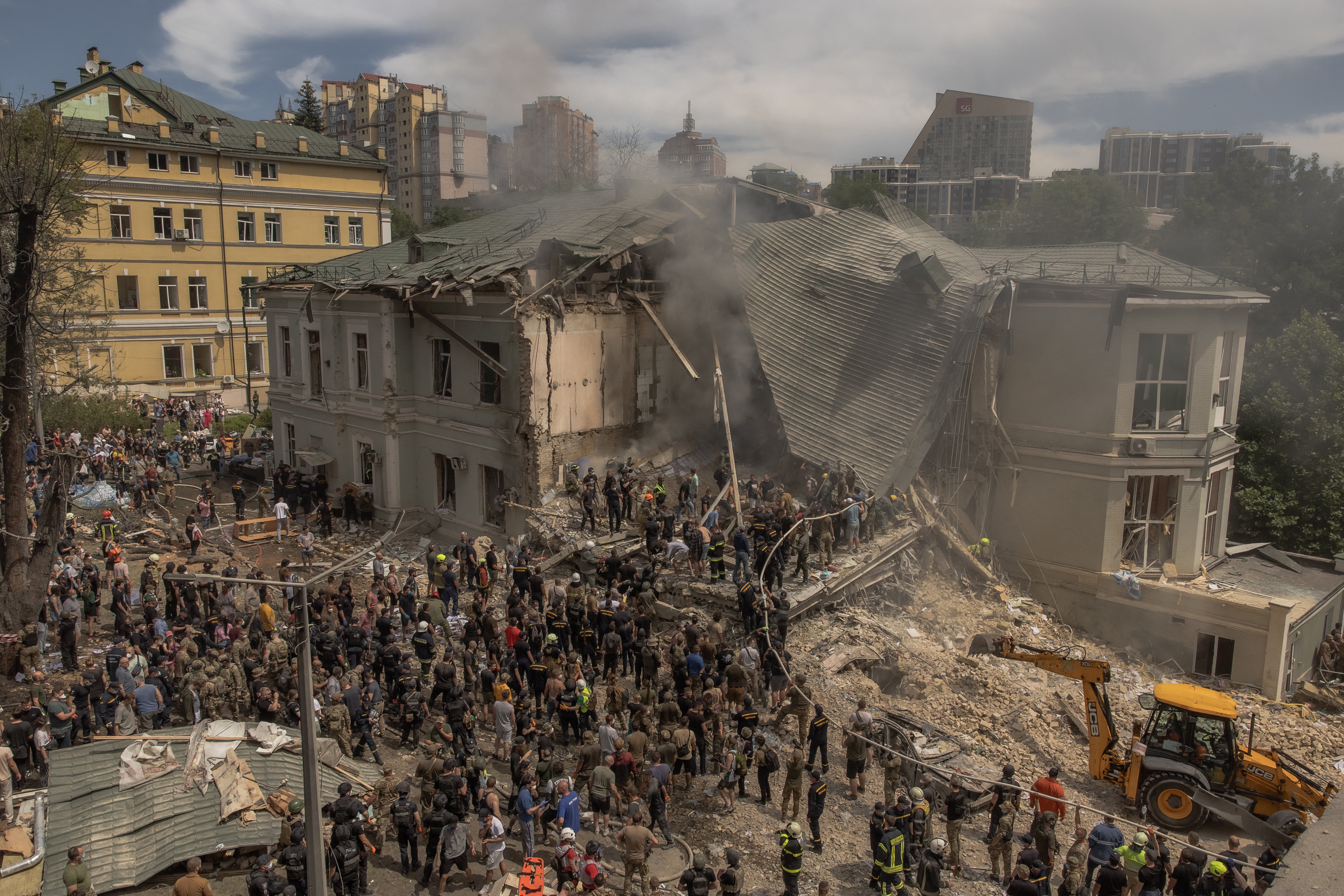 Emergency and rescue personnel along with medics and others clear the rubble of the destroyed building of Ohmatdyt Children's Hospital following a Russian missile attack in the Ukrainian capital