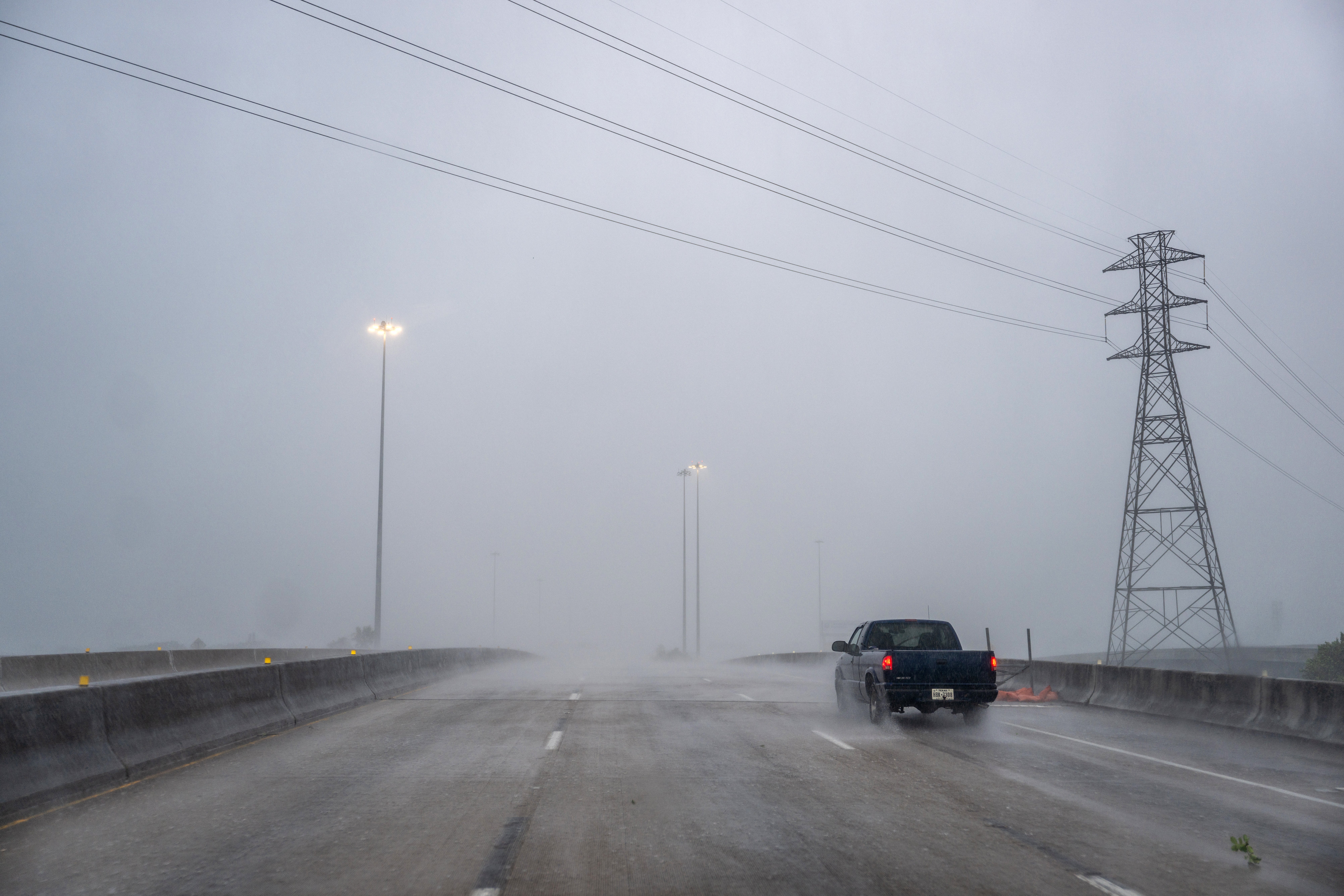 A car drives through heavy rain on a highway during Hurricane Beryl on July 8, 2024 in Houston, Texas.