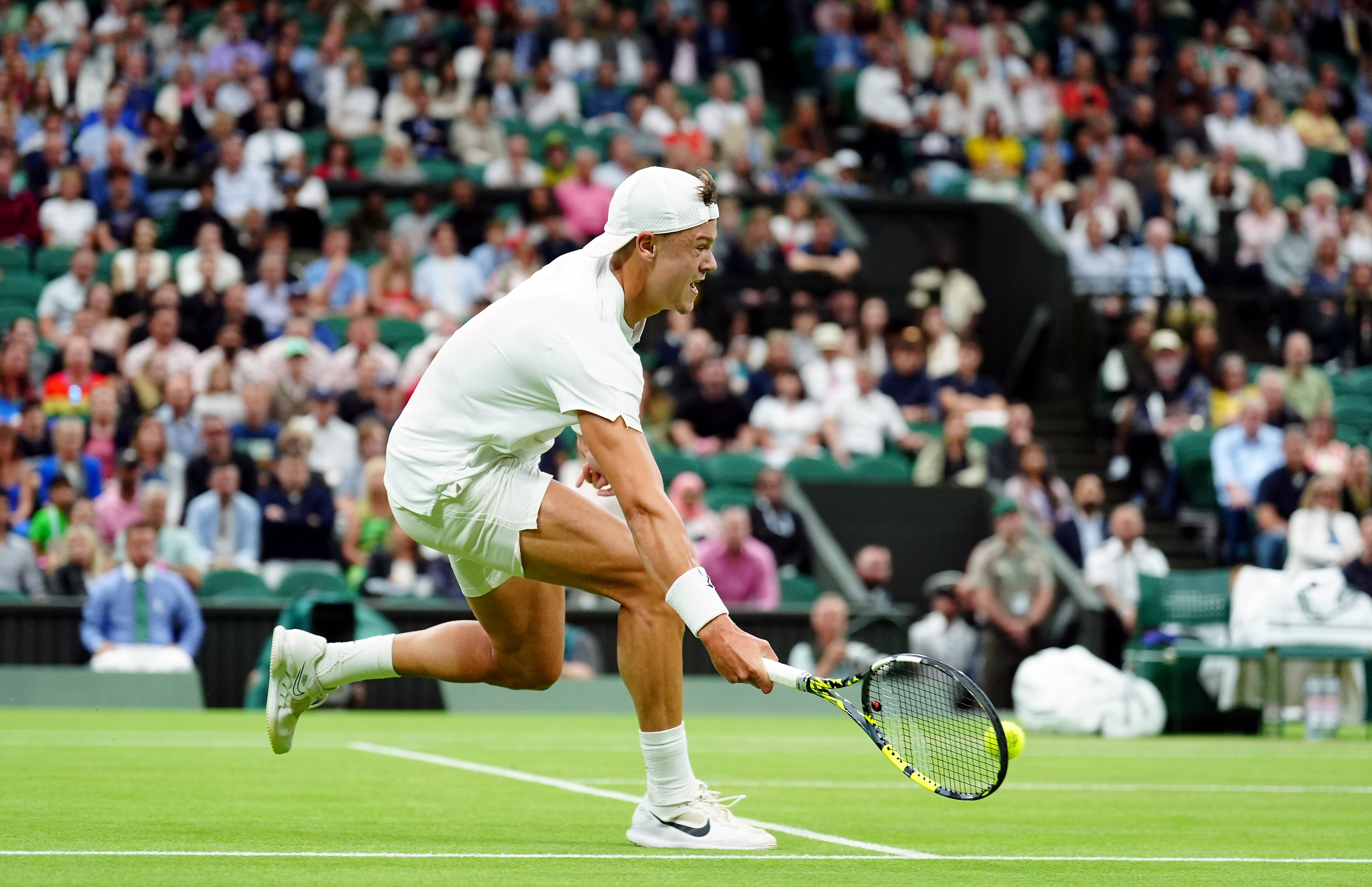 Holger Rune walks in to hit a forehand