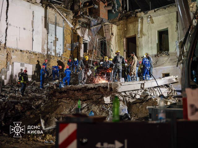 <p>Emergency service workers search through the rubble of a destroyed building in northwest Kyiv through the night</p>