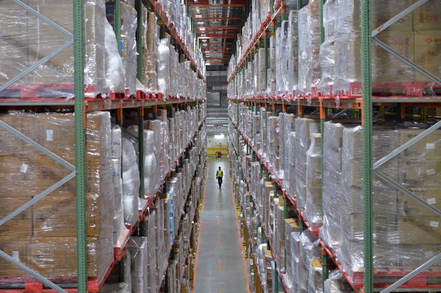 <p>An Amazon India worker walks in a warehouse on the outskirts of Bengaluru in 2018 </p>