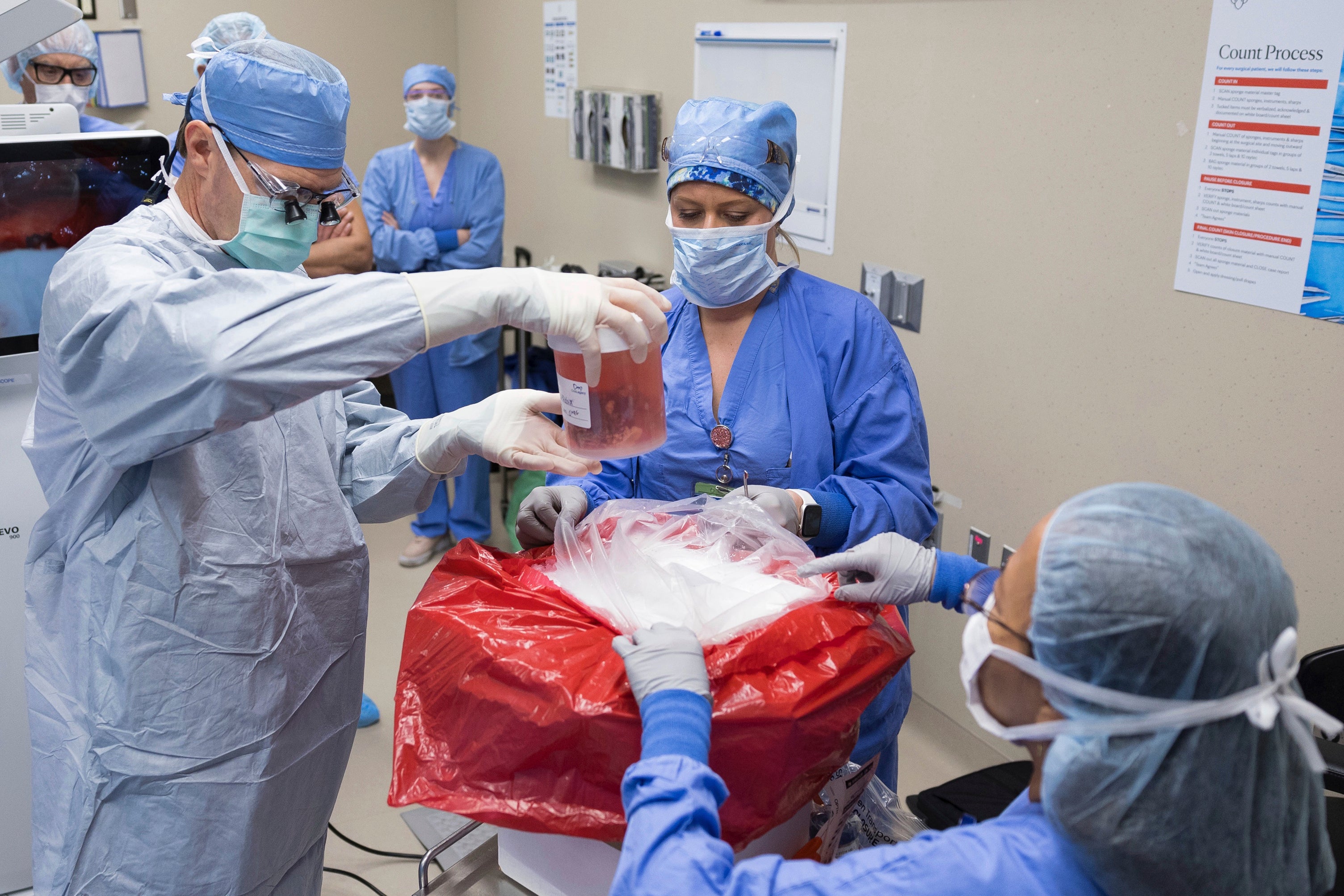 Dr. David Lott, Mayo Clinic’s chair of head and neck surgery, lifts the donor organ out of a perfusion container at Mayo Clinic Hospital in Phoenix