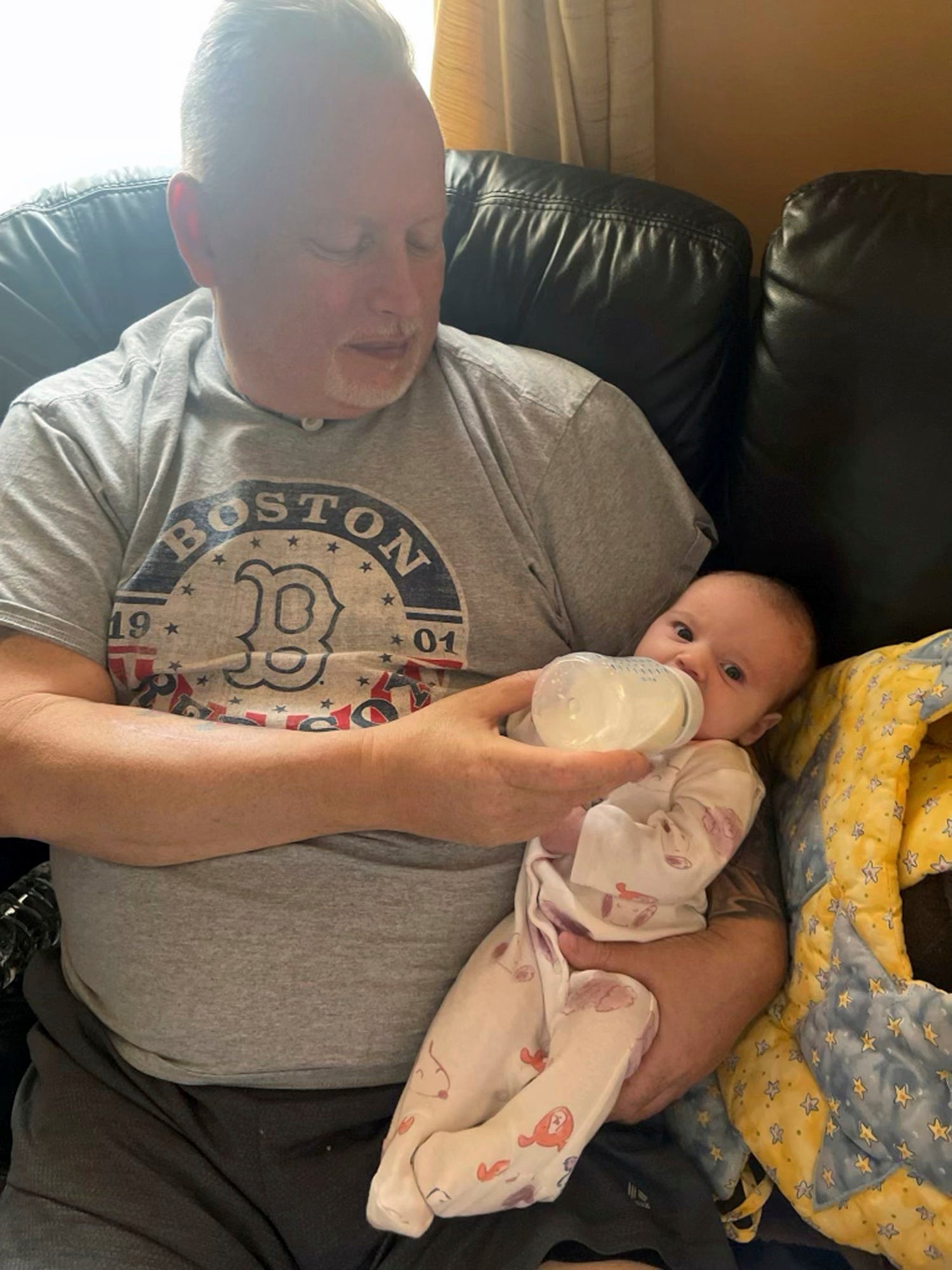 Marty Kedian holds his granddaughter in Pelham, N.H., on Feb. 26, 2023, before his larynx transplant