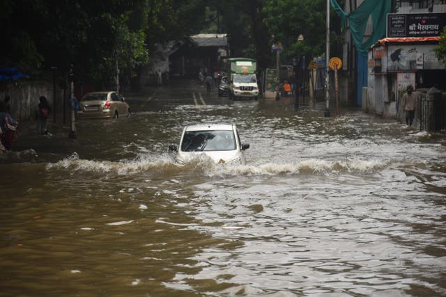 <p>Cars drive through an inundated street in Mumbai, India</p>