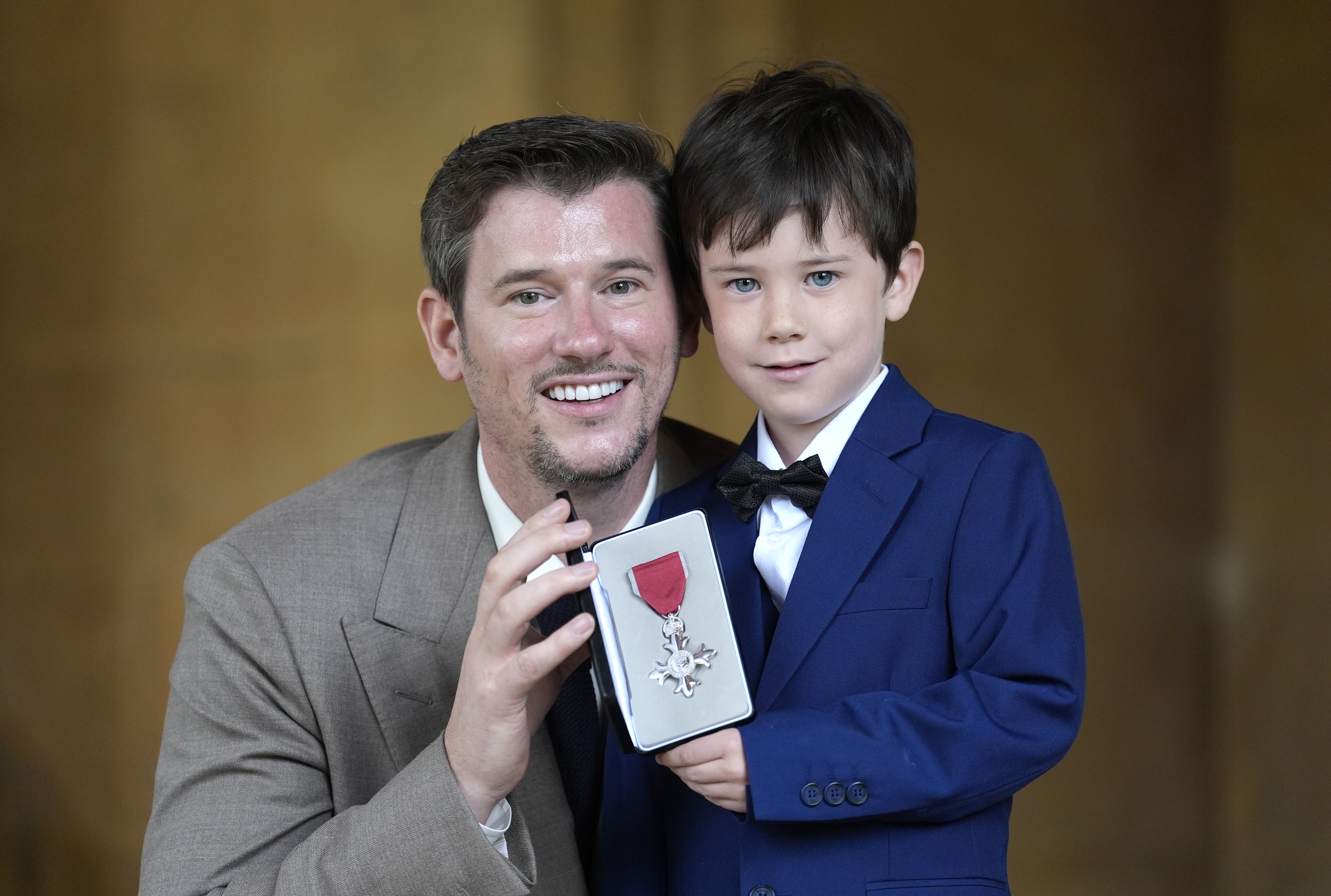 Chef Adam Handling with his son Oliver, after being made an MBE by the King (Andrew Matthews/PA)