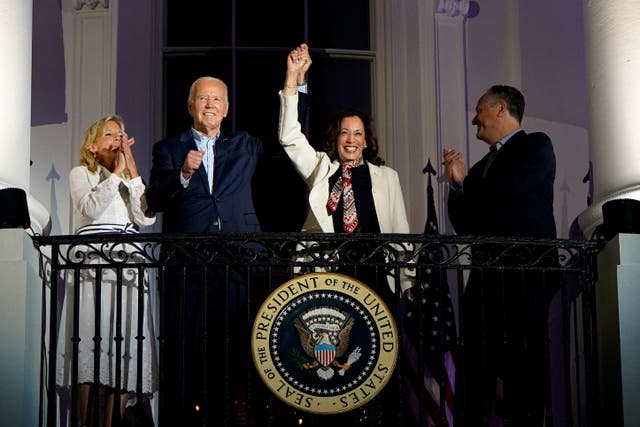 <p>President Joe Biden and Vice President Kamala Harris raise their hands as they stand on a White House balcony with first lady Jill Biden and second gentleman Doug Emhoff during an Independence Day celebration</p>