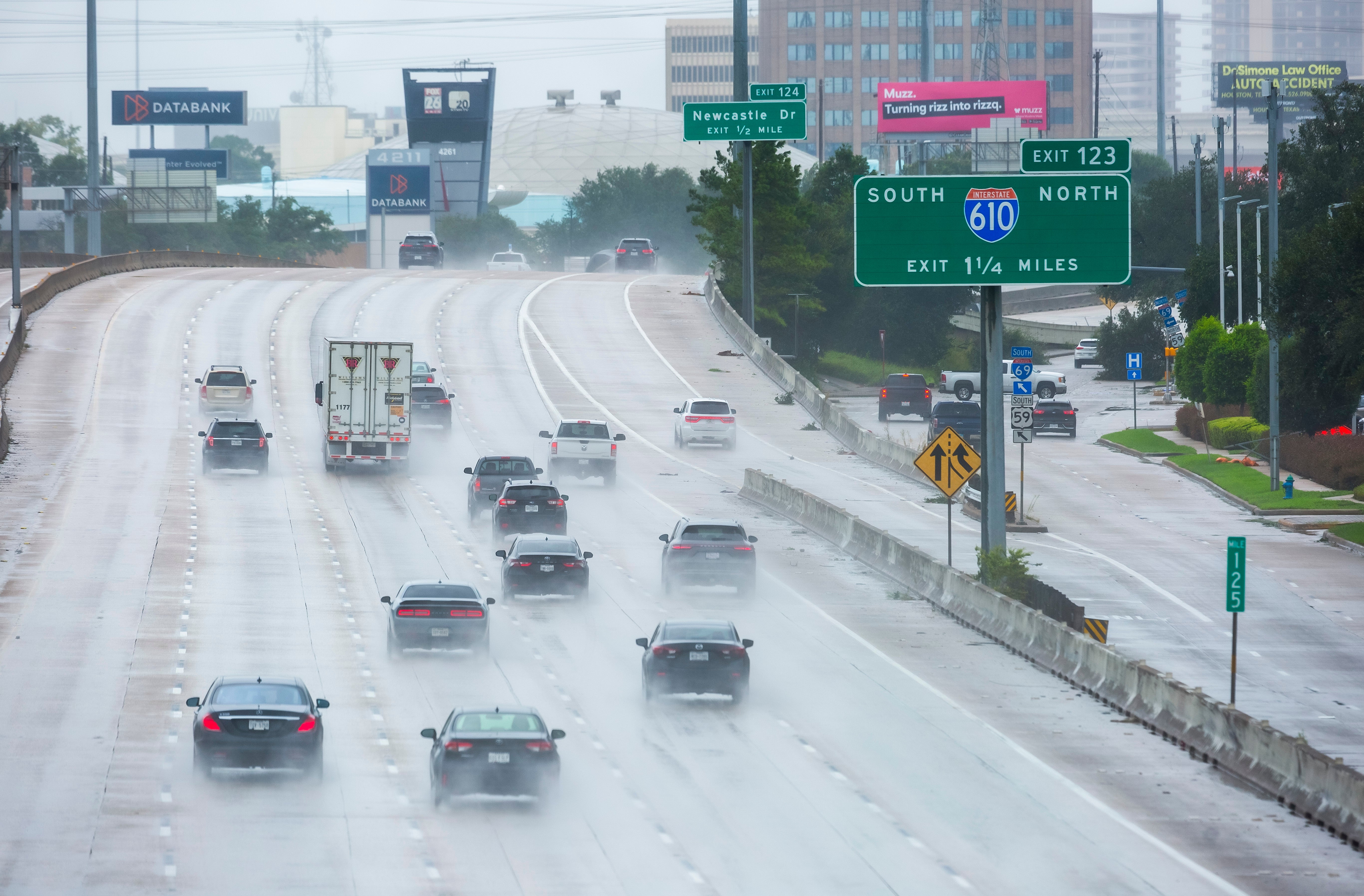 Cars travel through heavy rain from Hurricane Beryl in Houston, Texas on July 8