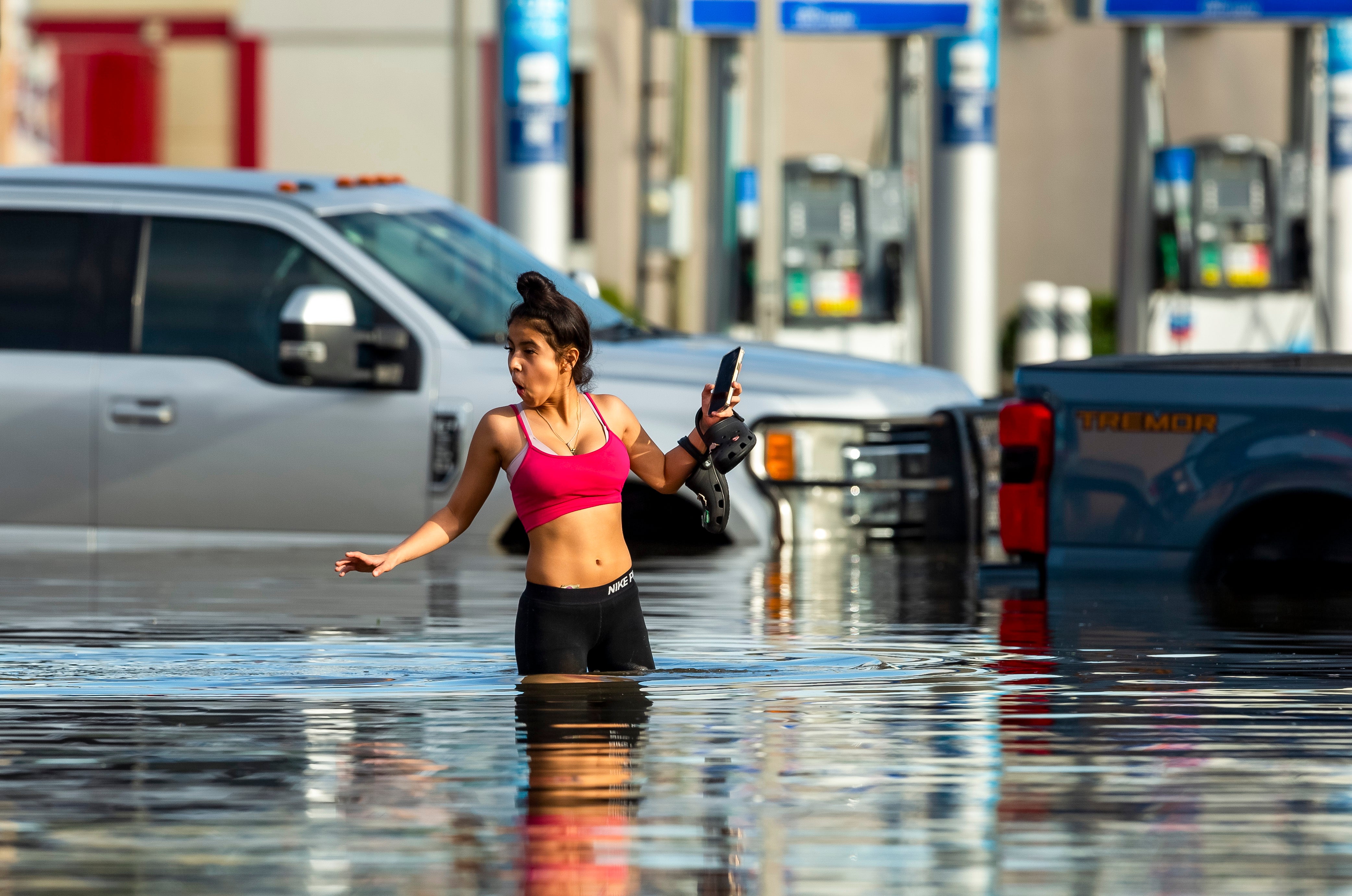 A woman navigates flood waters following heavy rain from Hurricane Beryl in Houston