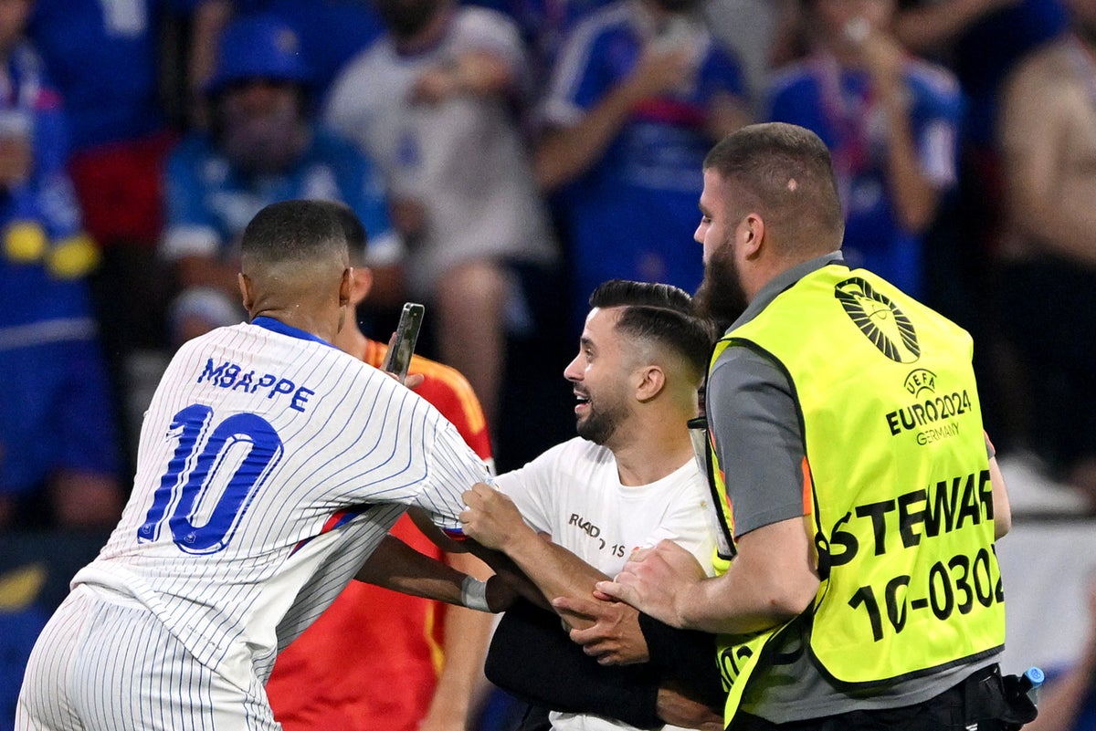 Pitch invader grabs Kylian Mbappe during Spain v France quarter-final at Euro 2024