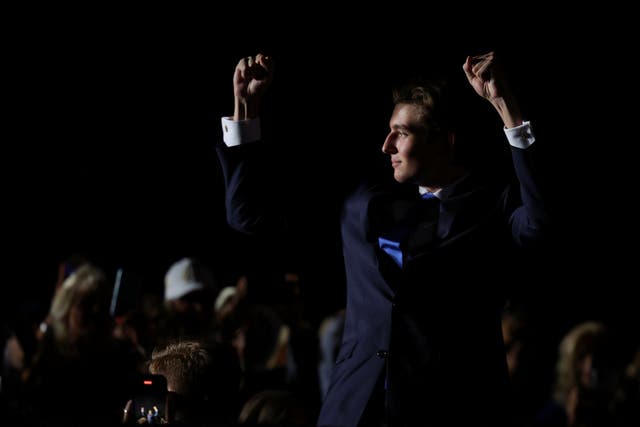 <p>Barron Trump pumps his fists and waves to a crowd at Donald Trump’s campaign rally in Florida on July 9. </p>