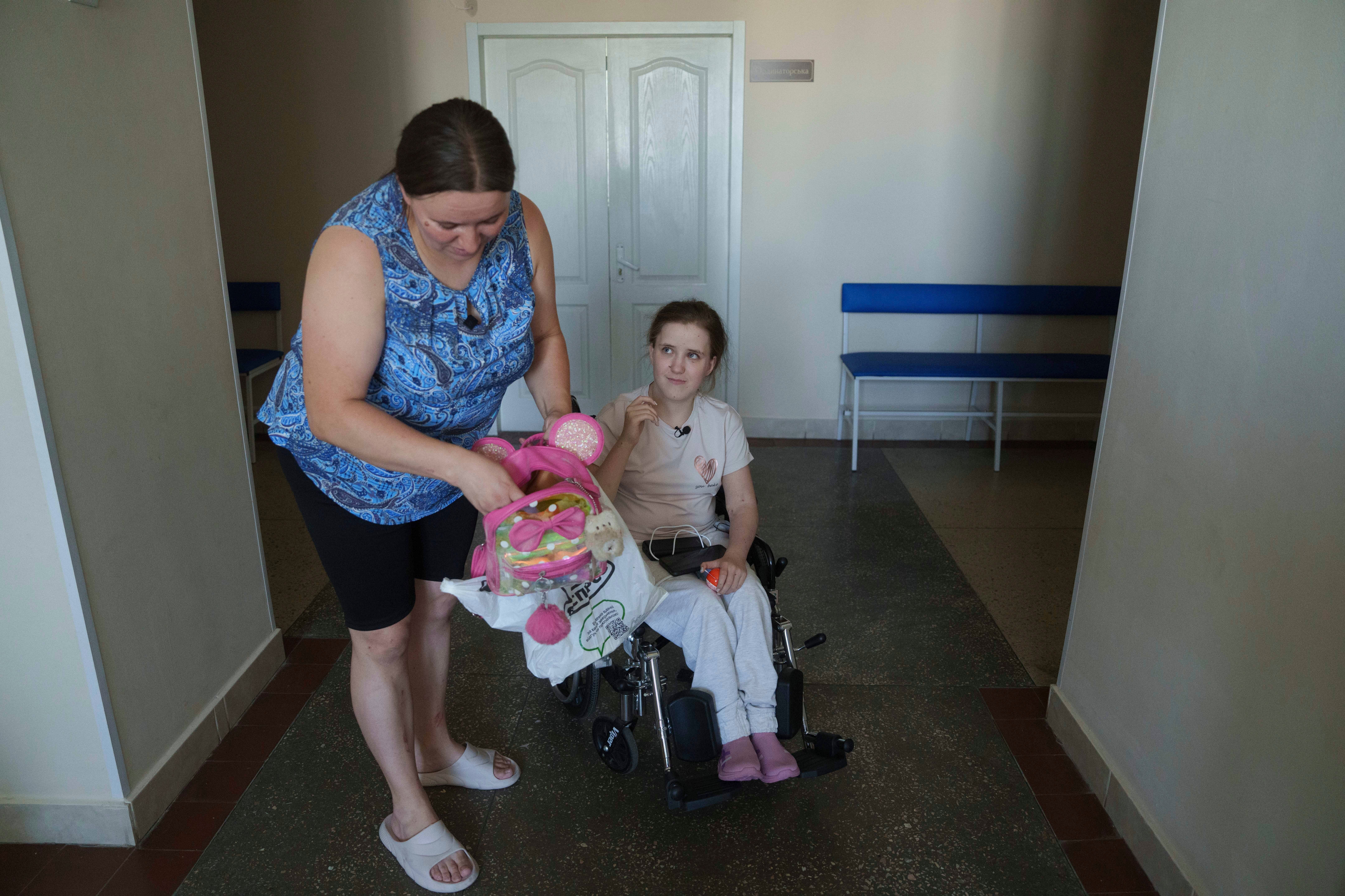 Oksana Femeniuk shows the backpack of her daughter Solomiia, a day after they survived a Russian missile strike on Okhmatdyt children's hospital, in Kyiv,