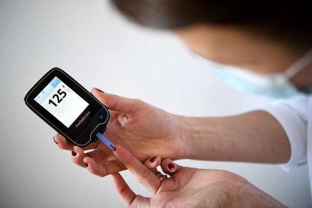 <p>A woman with diabetes uses a glucometer to measure the glycemia in her blood in Paris </p>